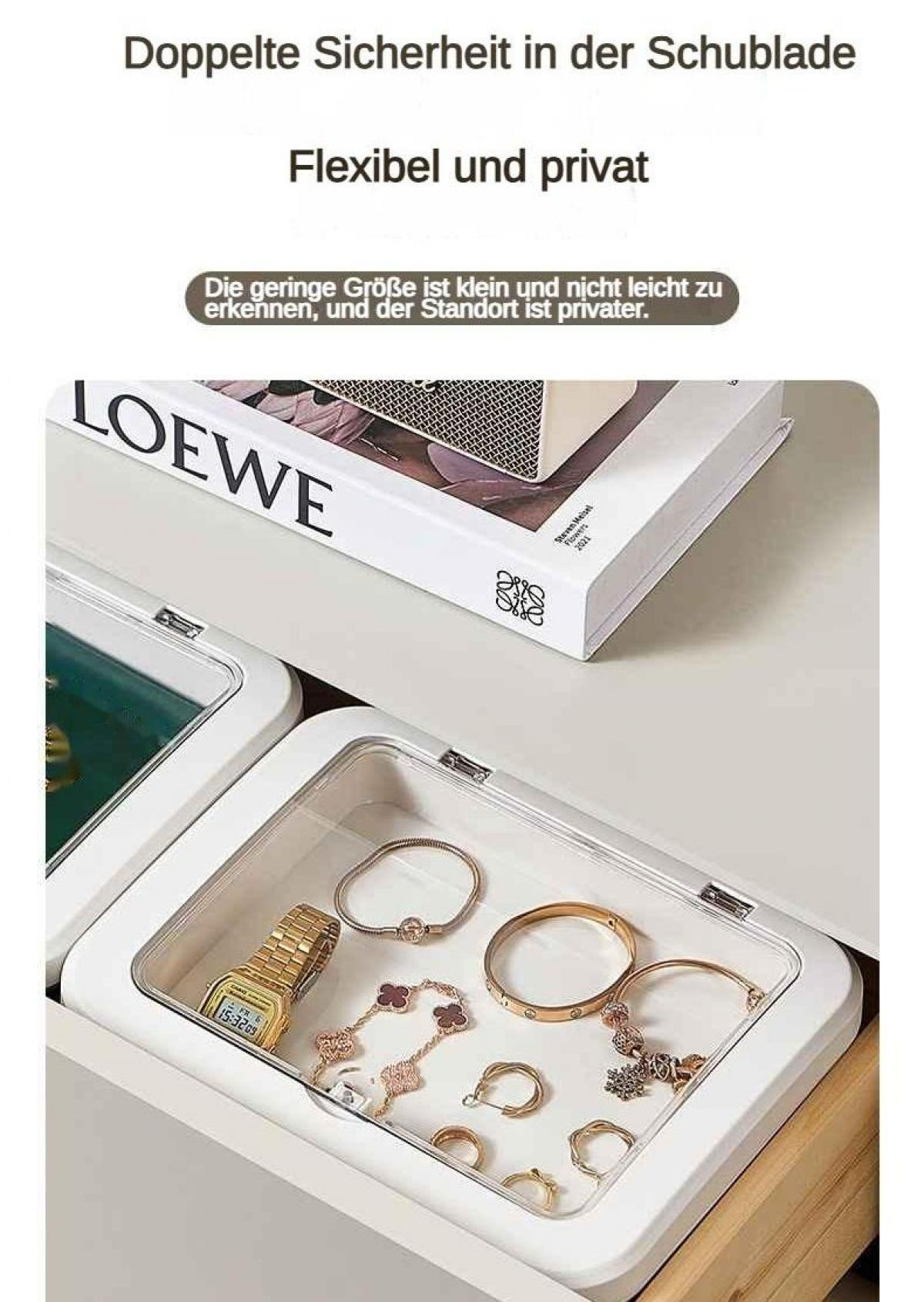 Eine offene weiße Schublade mit Schmuck darin, darunter eine goldene Uhr und Armbänder.