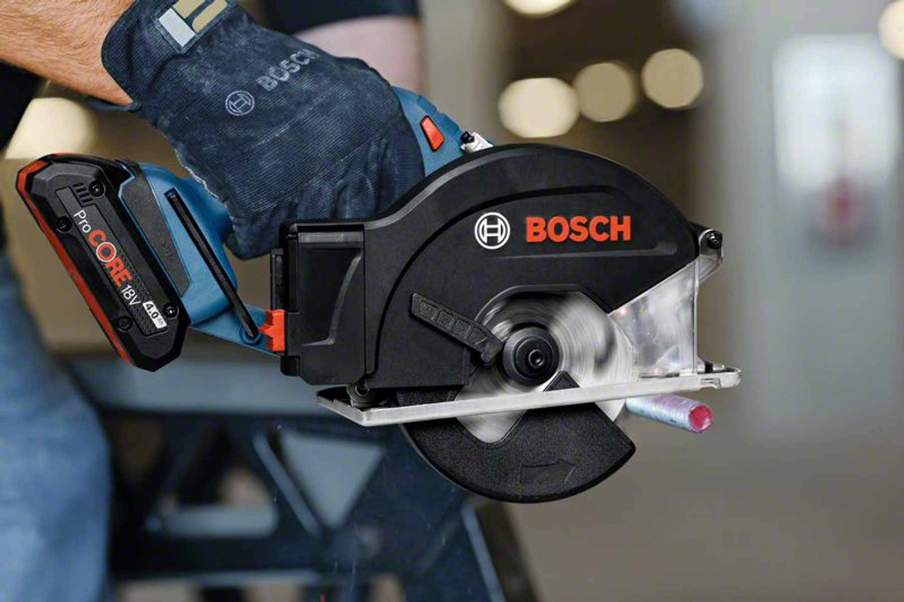 Ein Bosch Akku-Trennschleifer schneidet ein Metallrohr. Mit Handschuh bedient.