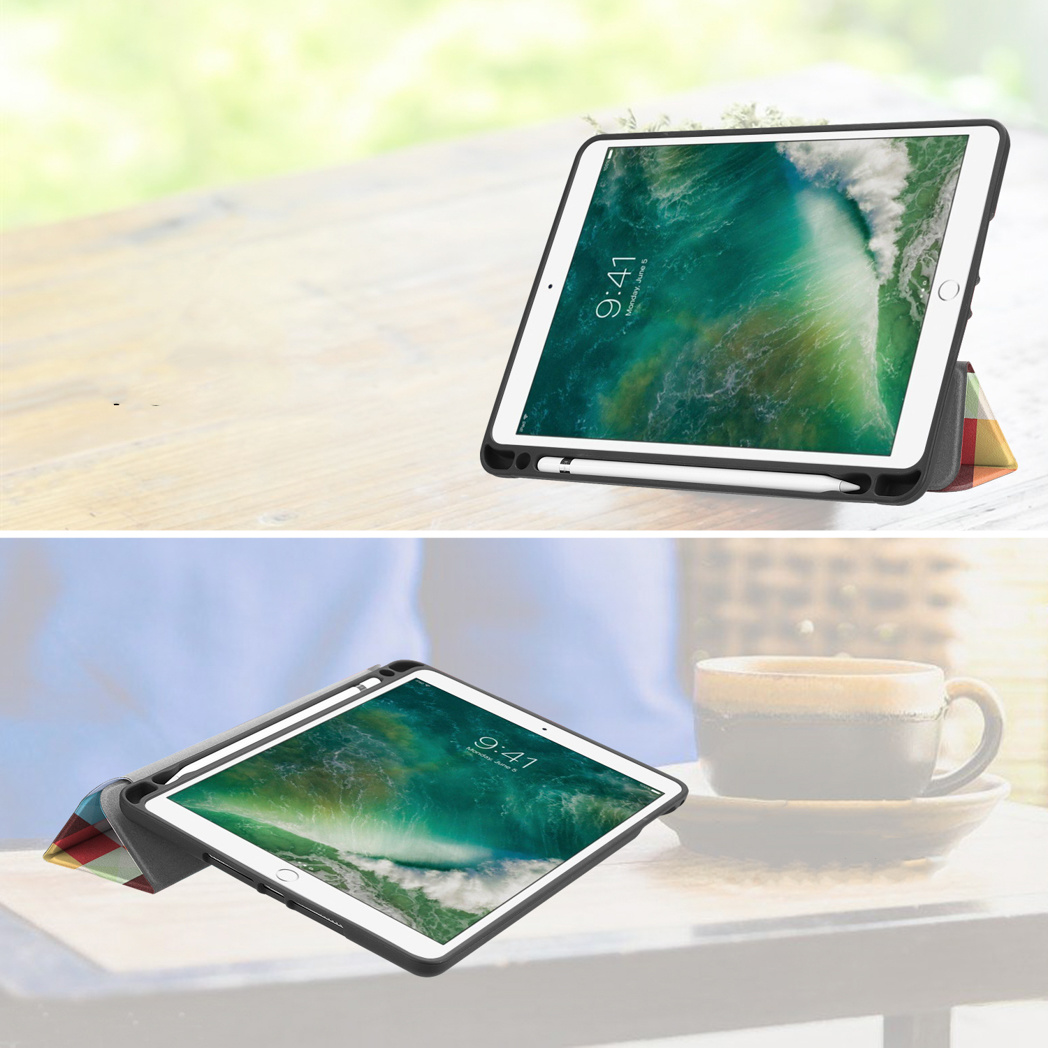 Een tablet met pen in een standaard op een houten tafel en op een tafel met kopje.
