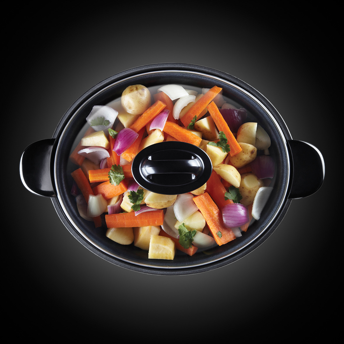 Una olla llena de patatas, zanahorias, cebollas y perejil crudos, lista para cocinar.
