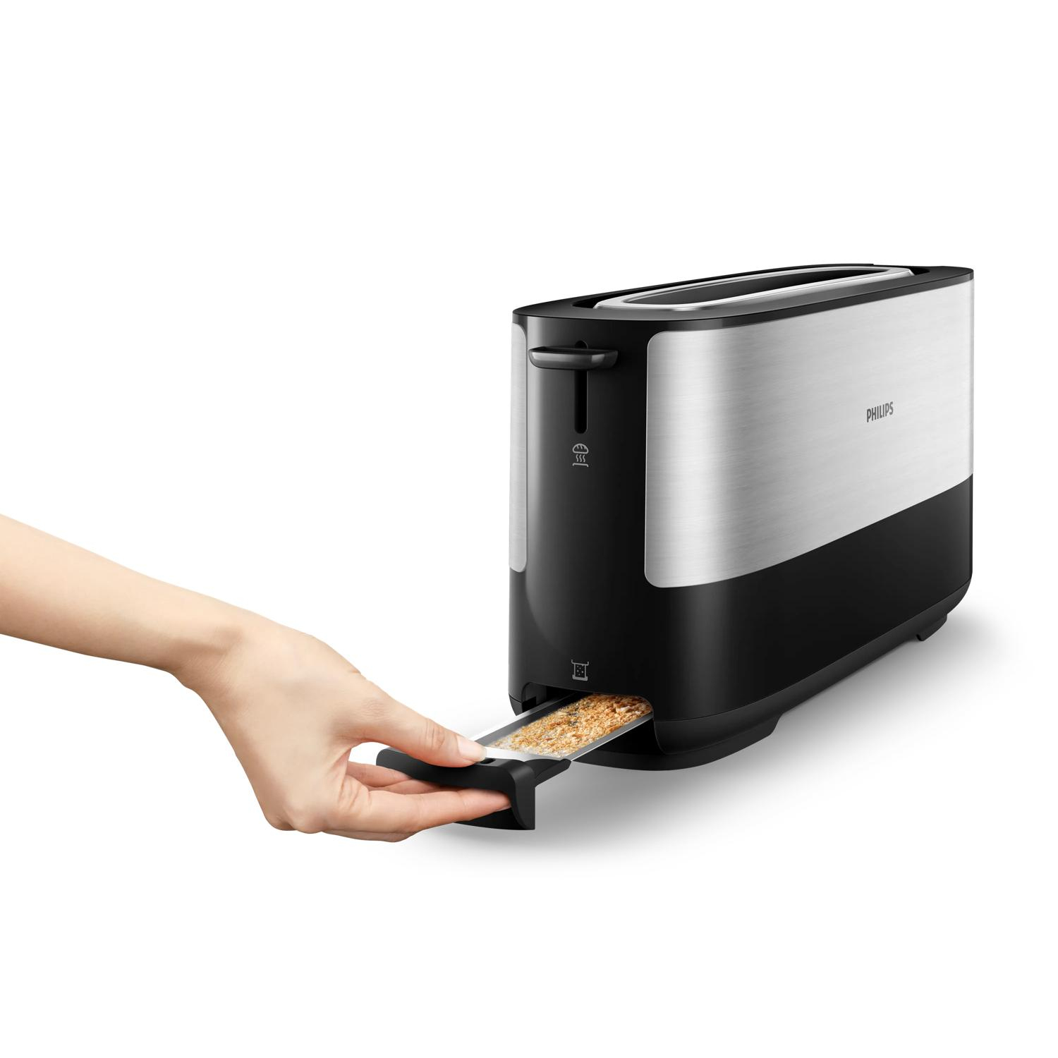 Eine Hand zieht einen Toast aus einem schwarzen Philips-Toaster mit silberner Oberfläche.