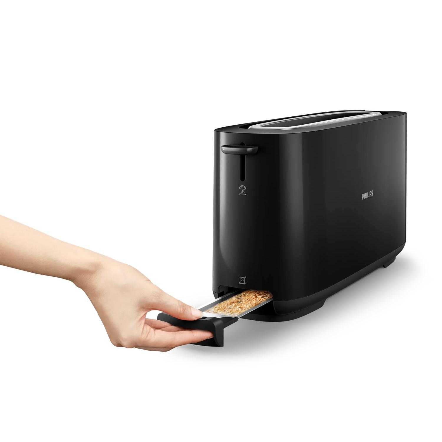 Una mano inserisce il toast in un tostapane Philips nero su sfondo bianco.