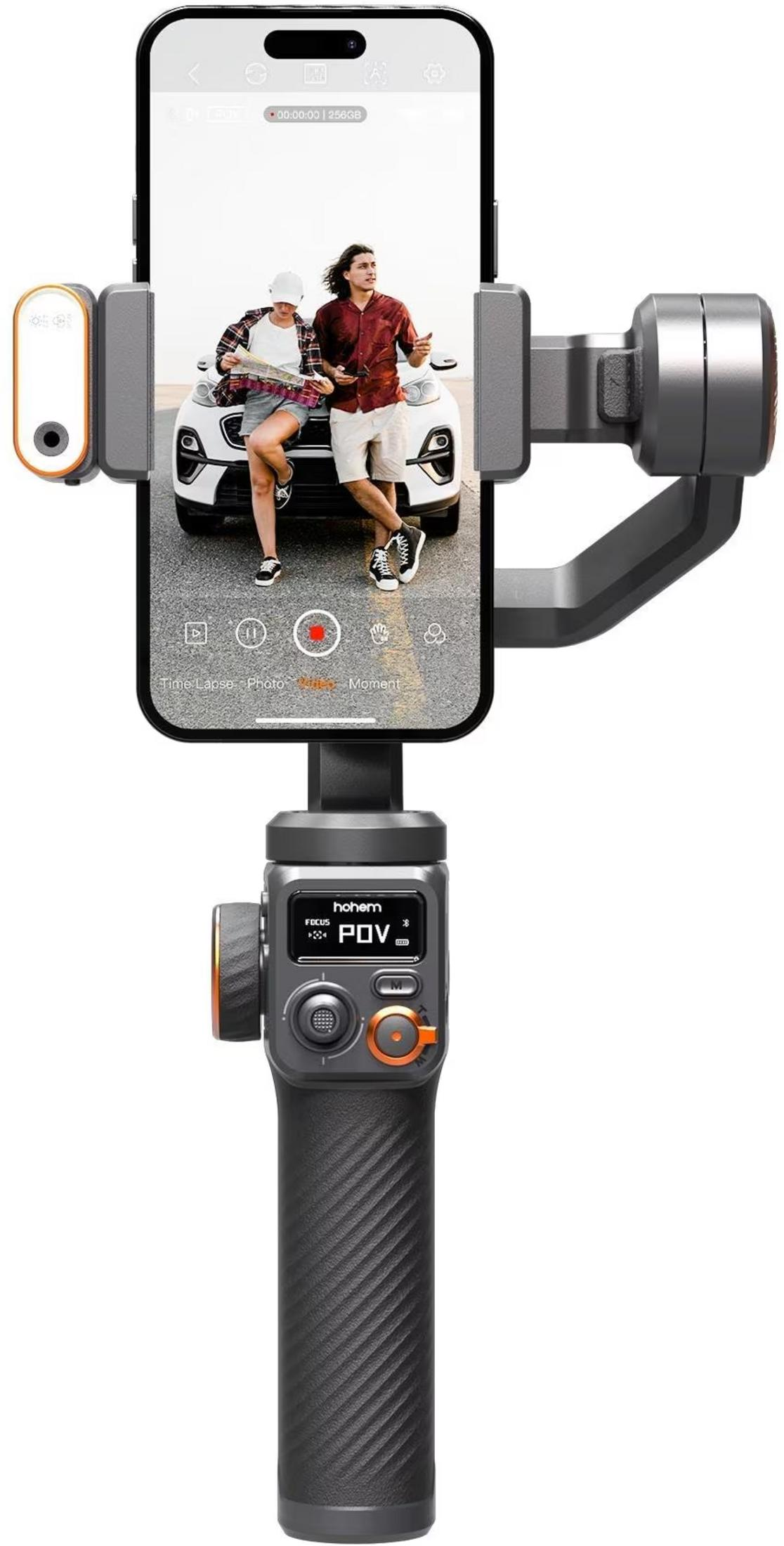 Gimbal trzyma smartfon pokazujący parę przed samochodem.
