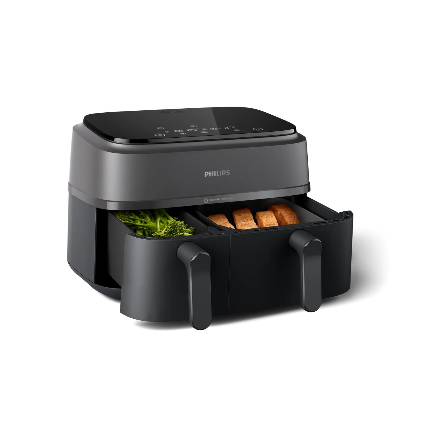 Una friggitrice ad aria Philips scura con due cassetti, riempiti di broccoli e pane.