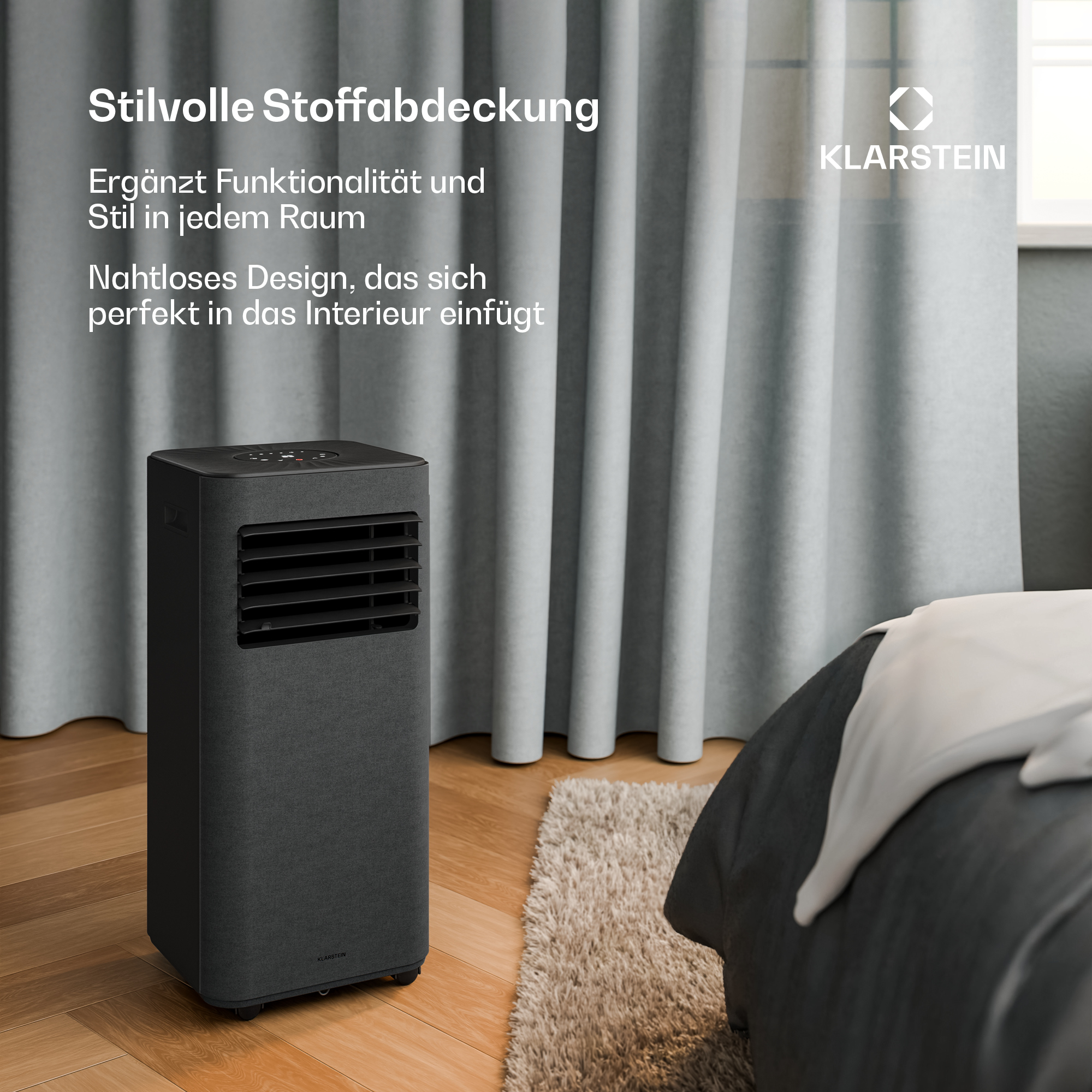 Un ventilatore a torre rivestito in tessuto scuro si trova su un parquet accanto a un letto.