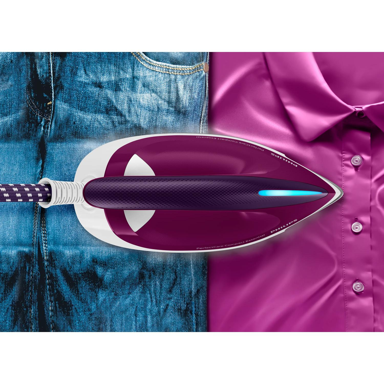 Una plancha sobre jeans azules y una camisa morada.