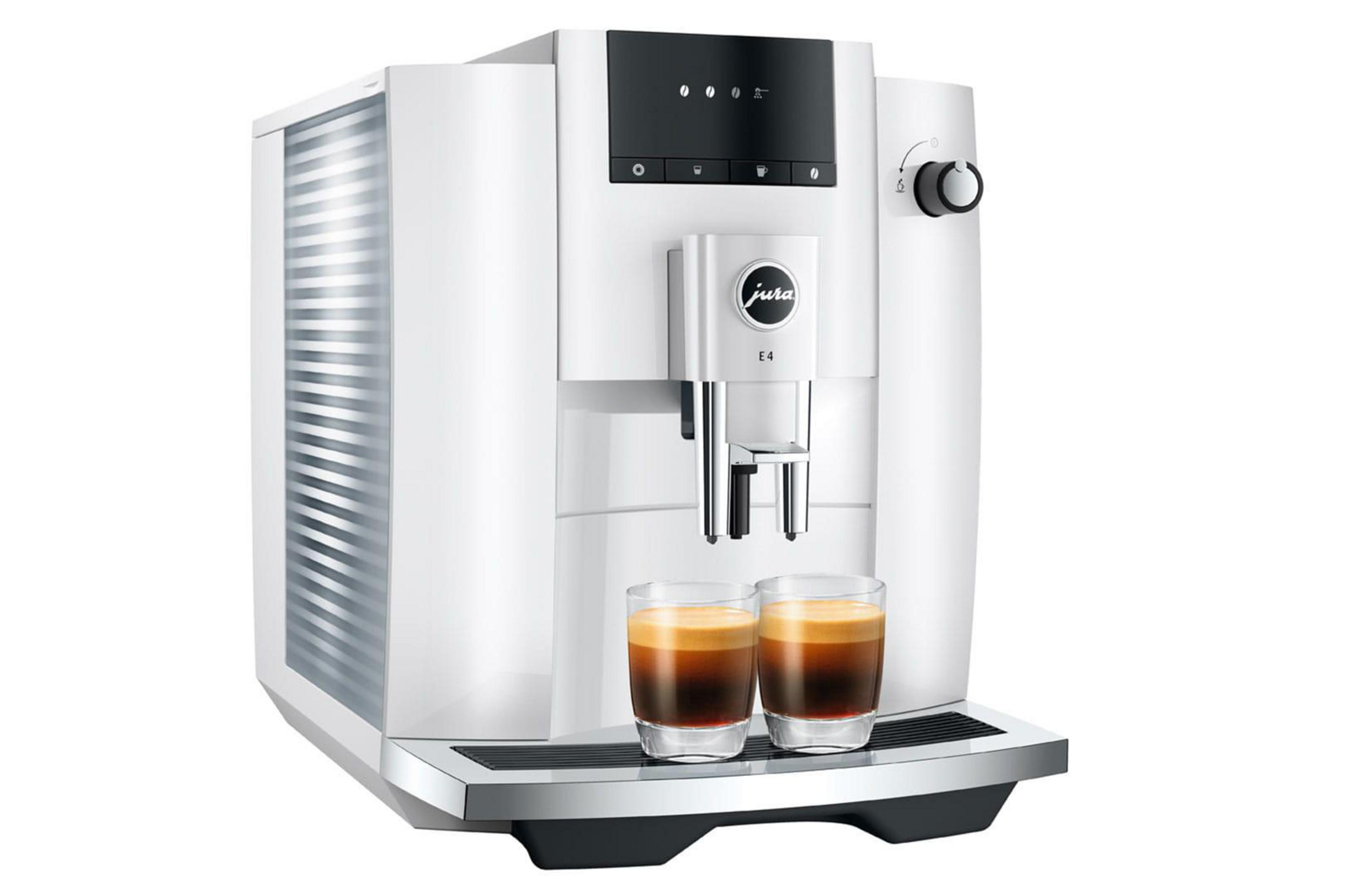 Una macchina da caffè bianca con due bicchieri di espresso davanti.
