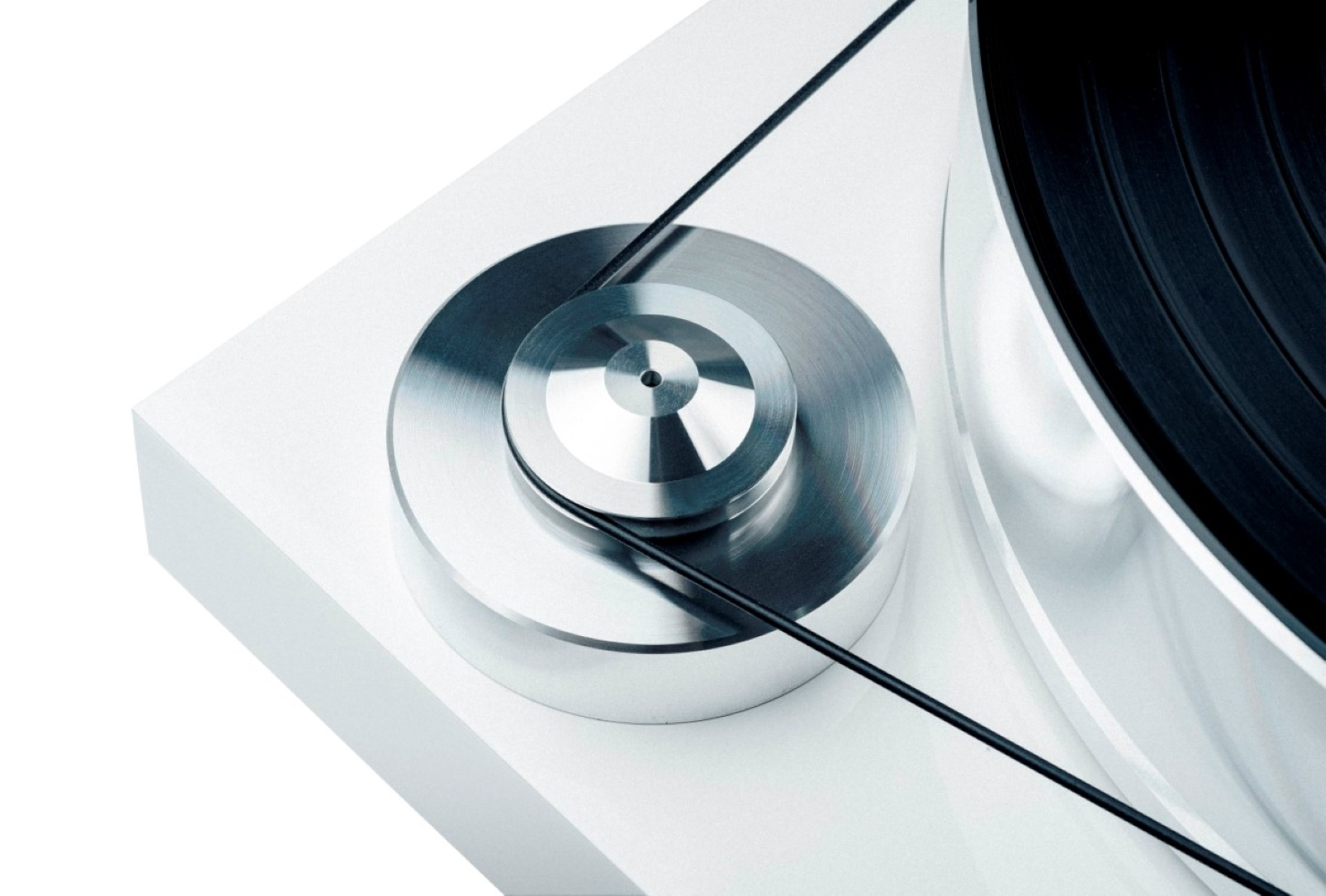 Zbliżenie białego gramofonu z metalowym silnikiem i czarnym paskiem.