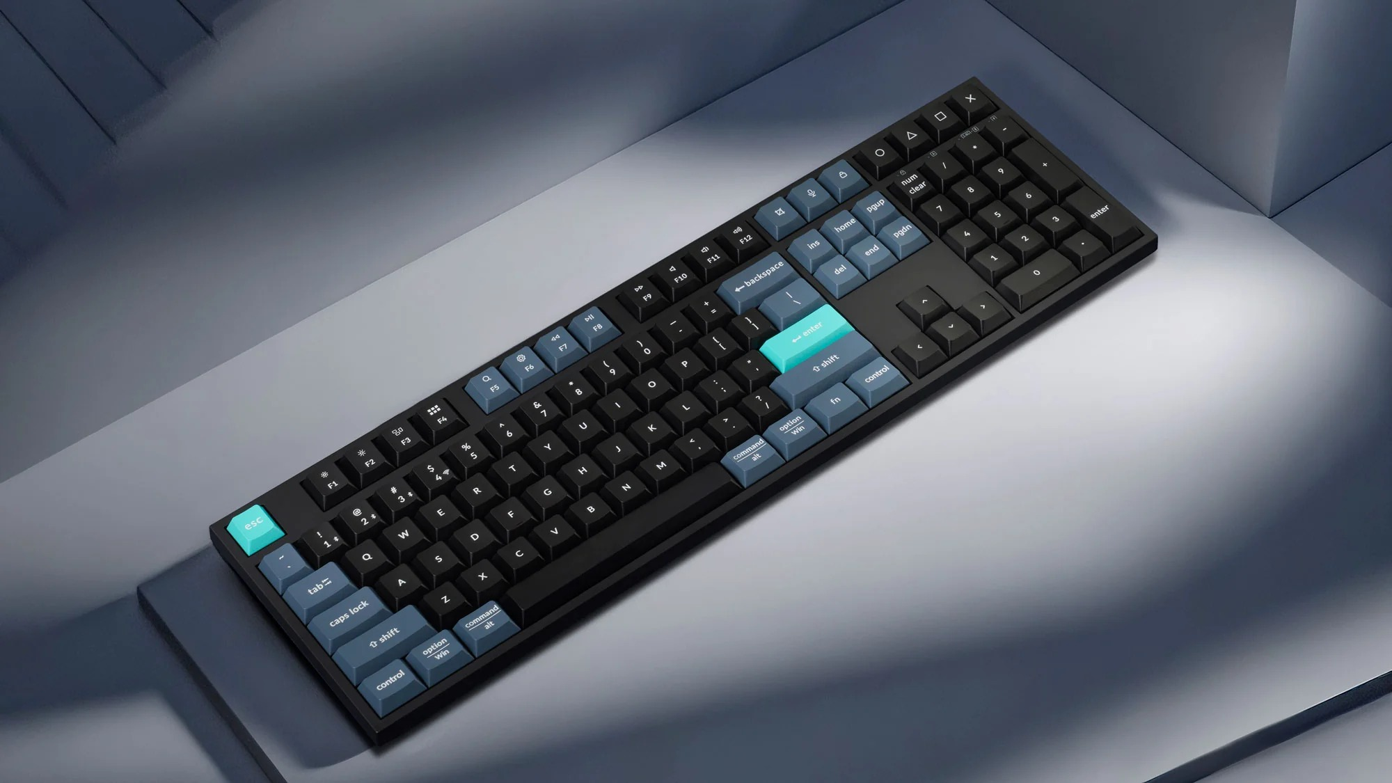 Czarna klawiatura z niebieskimi i turkusowymi klawiszami na szarym tle.