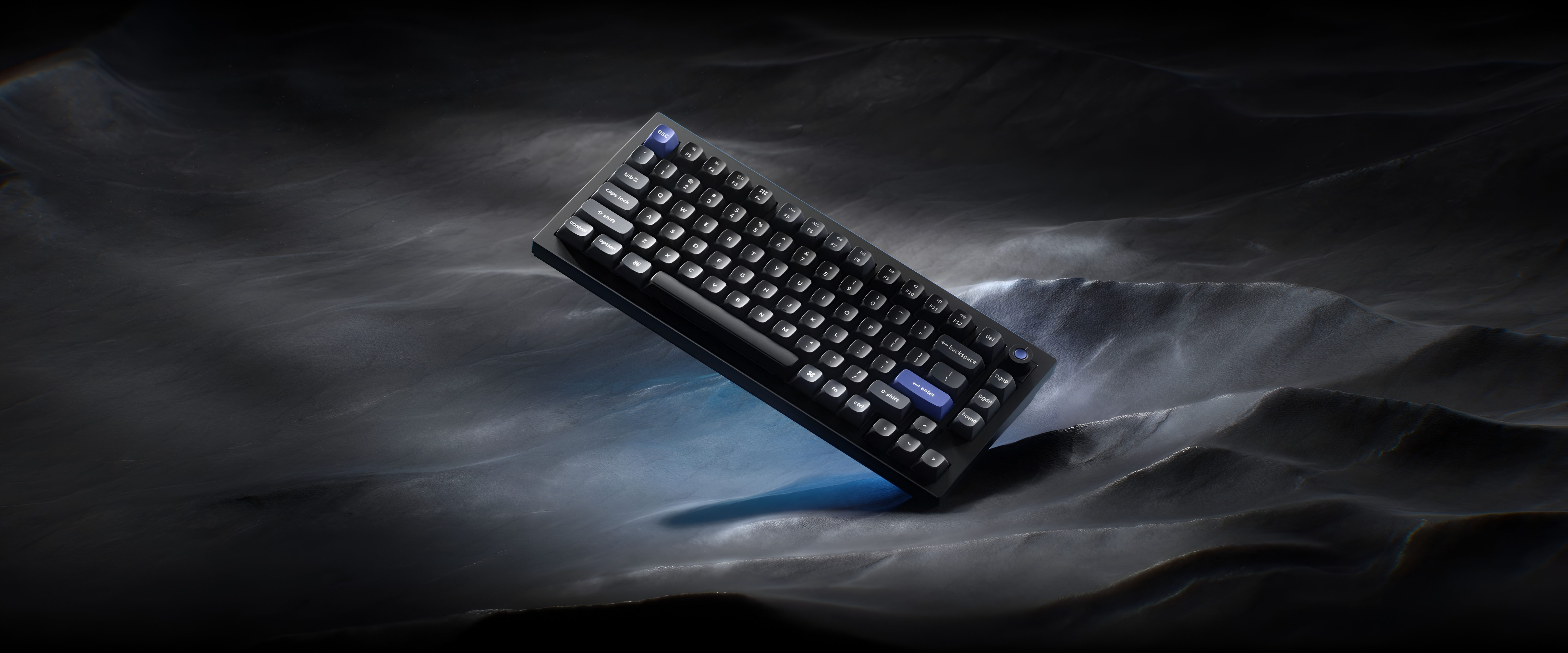 Czarna klawiatura z niebieskimi klawiszami akcentującymi na ciemnym, pofałdowanym tle.
