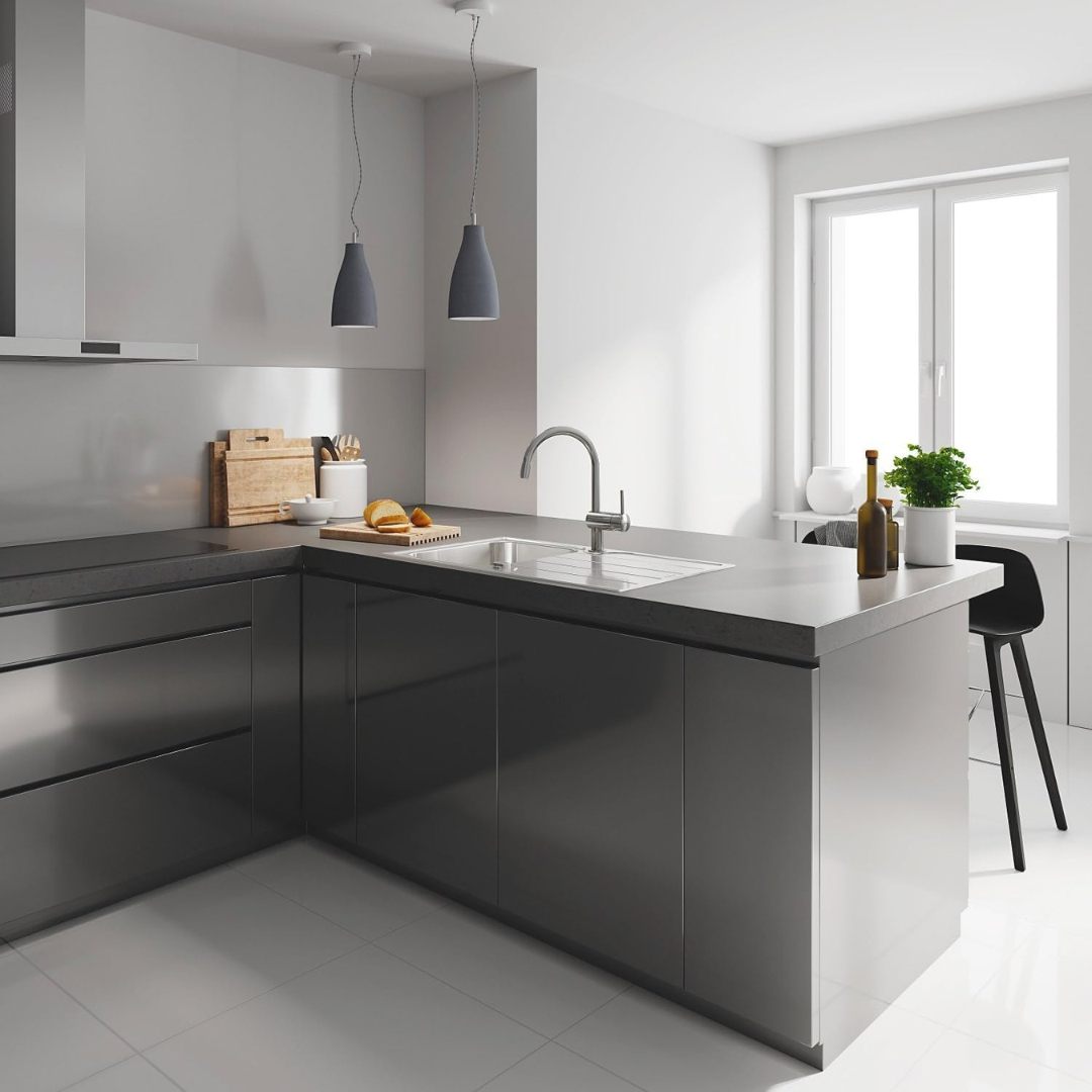 Cucina moderna con mobili scuri, lavello, lampade a sospensione e finestra.