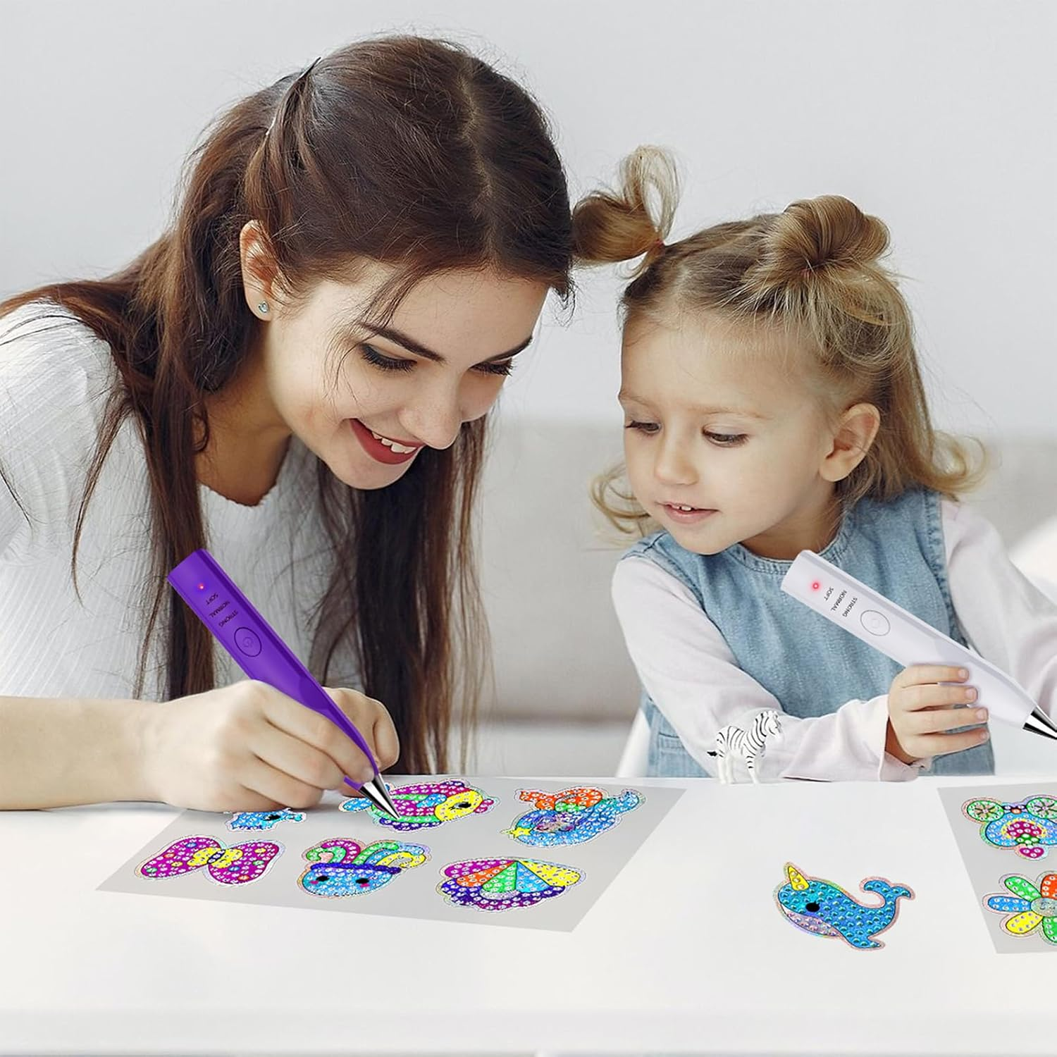 Mutter und Tochter basteln mit Diamantenstiften auf bunten Aufklebern.