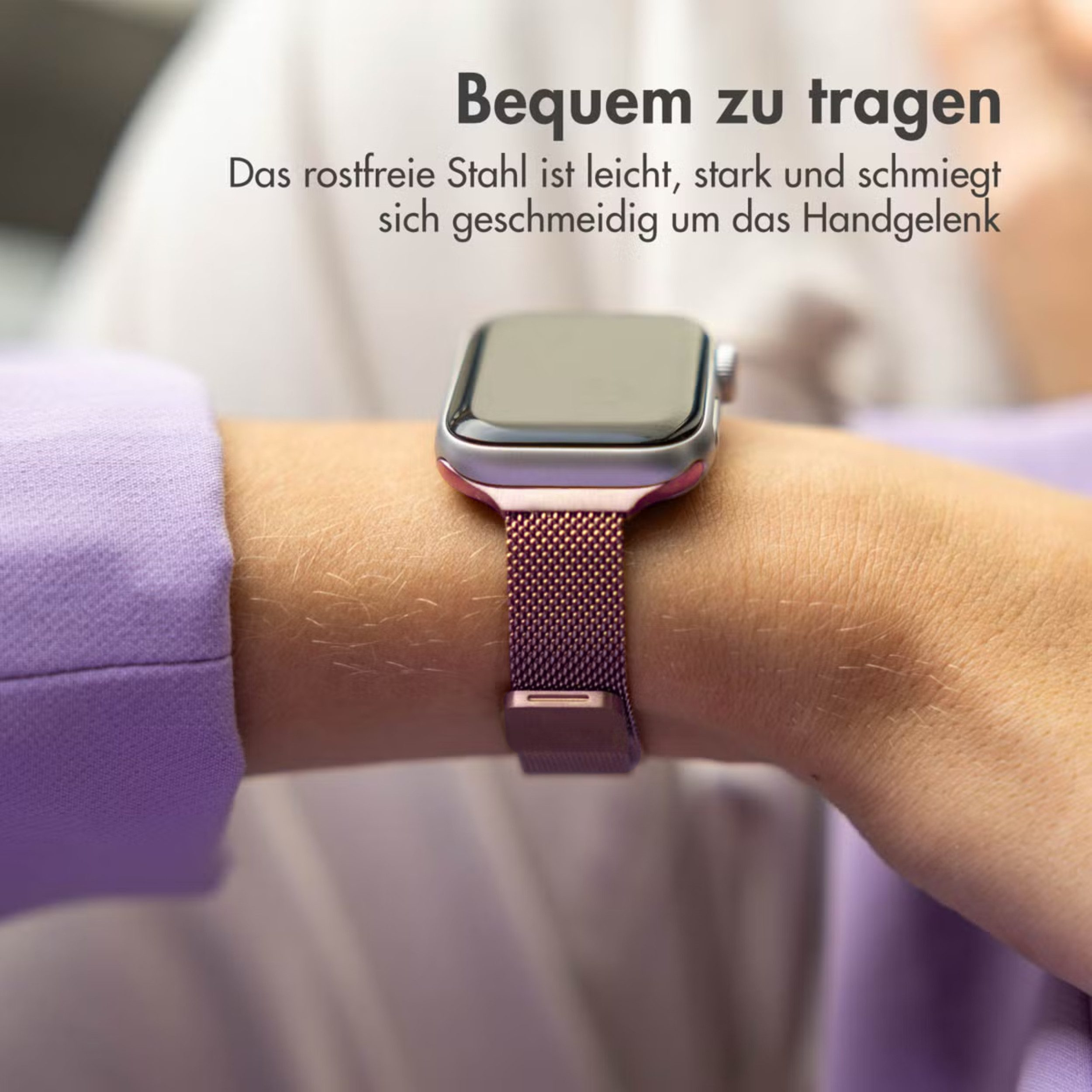 Eine silberne Smartwatch mit einem lila Netzarmband an einem Handgelenk.