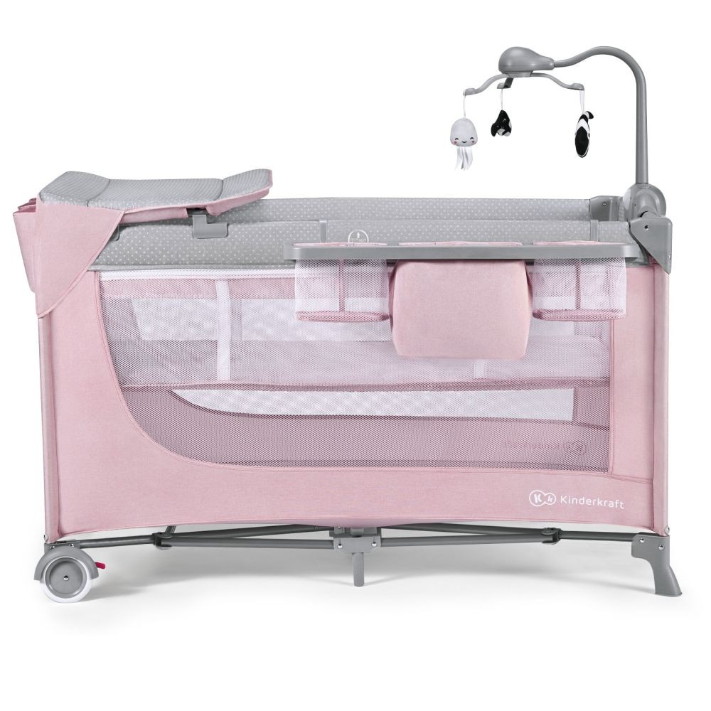 Ein rosa Reisebett mit Wickelauflage und Spieluhr, auf weißem Hintergrund.