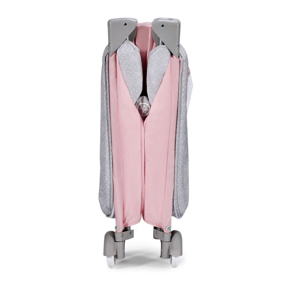 Ein zusammengeklapptes Kinderbett in Rosa und Grau mit Sternenmuster.
