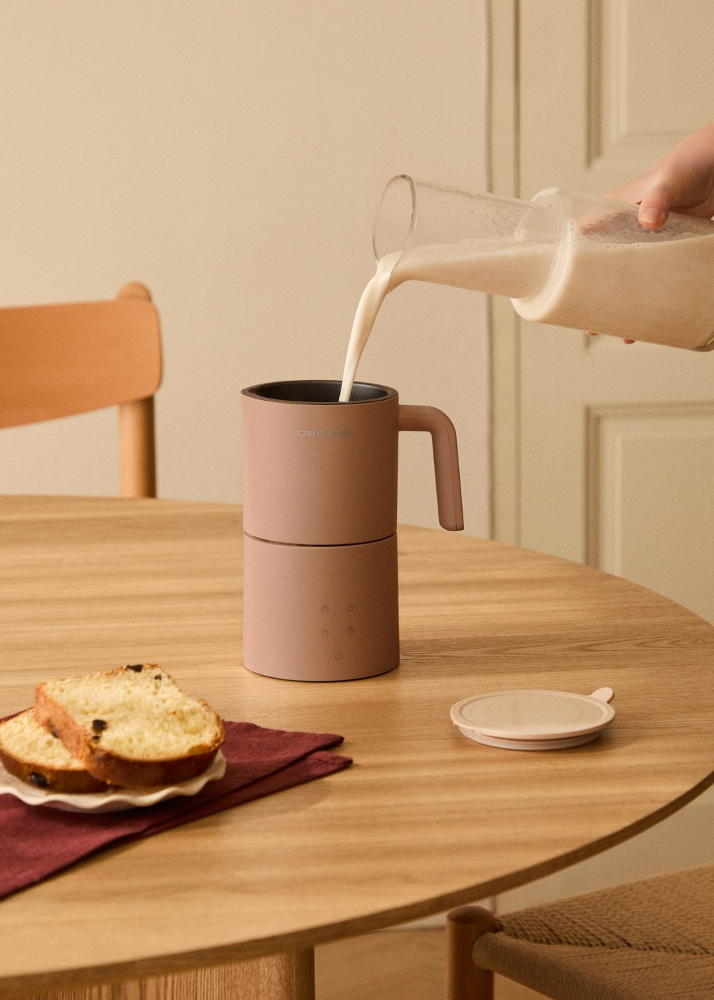 La leche se vierte en una taza, con rebanadas de pan al lado.