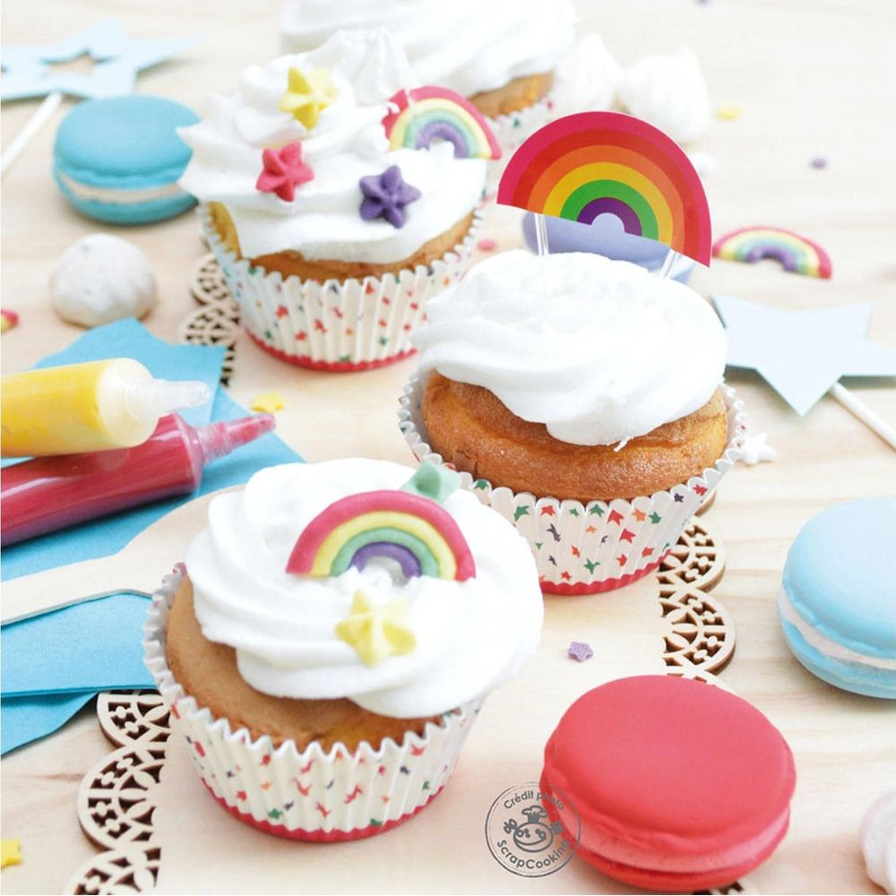 Bunte Cupcakes mit Regenbogen- und Sternverzierungen, Makronen und Dekorationen.