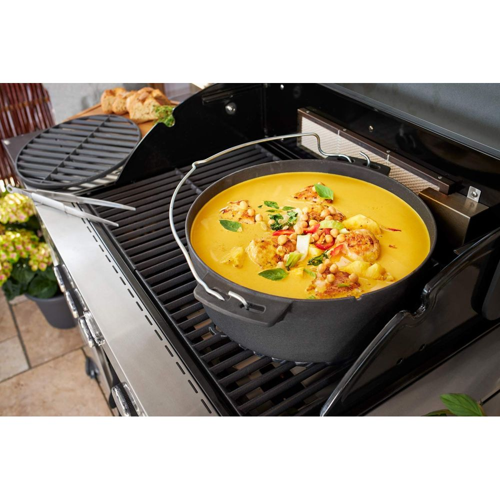 Una pentola di curry giallo con gamberi su una griglia.