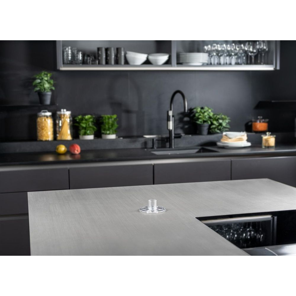 Moderne Küche mit Edelstahlinsel, schwarzem Wasserhahn und Gläsern im Kühlschrank.