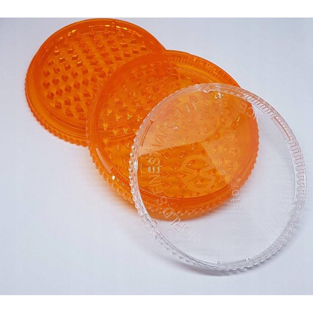 Tre grinder arancioni con coperchio trasparente sopra.