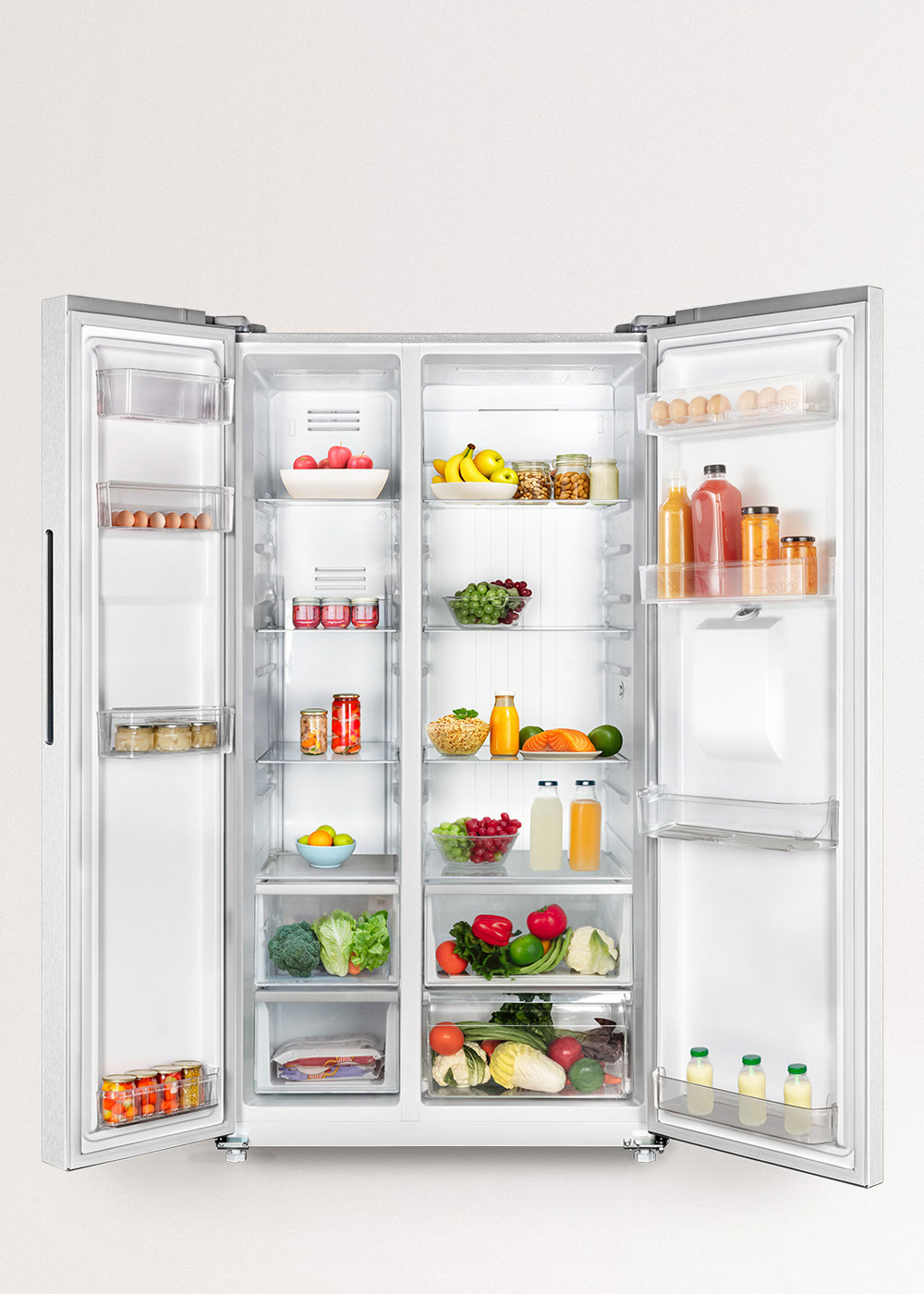 Refrigerador abierto lado a lado con frutas, verduras, bebidas y huevos.
