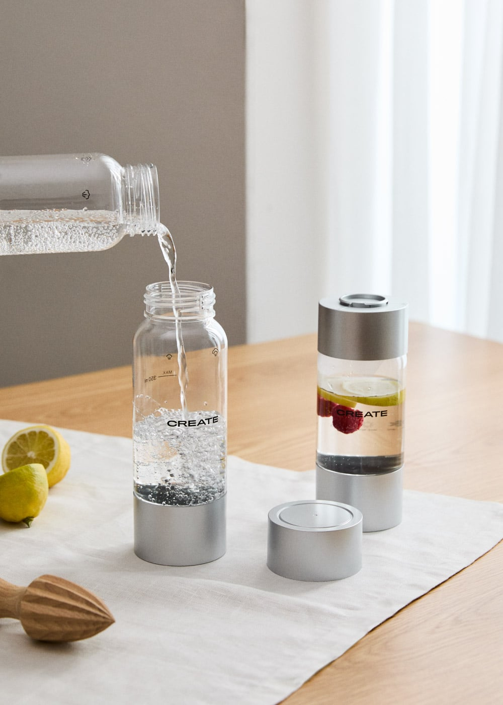 Se vierte agua en una botella; al lado hay una botella llena con fruta.