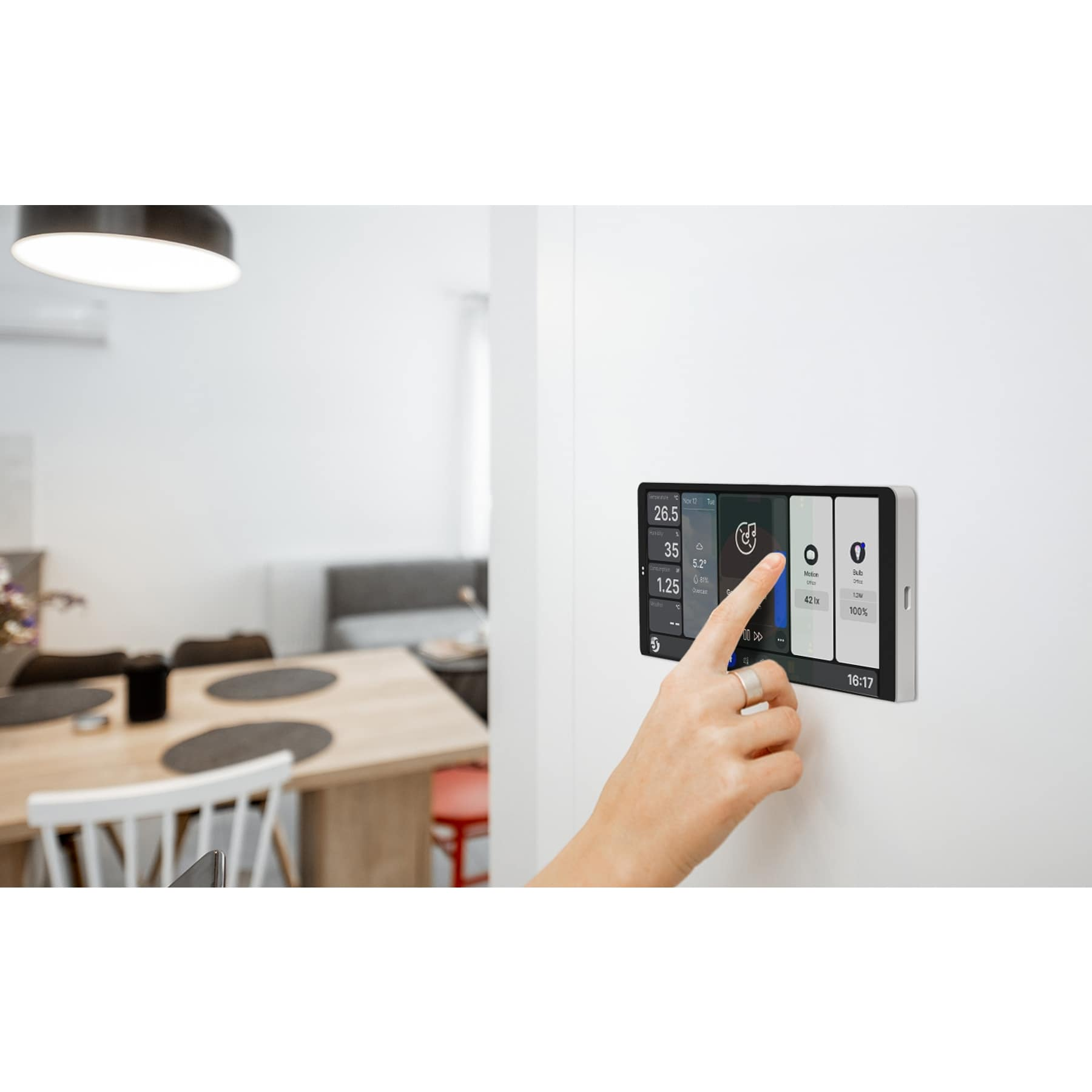 Una mano aziona un display smart home che mostra informazioni sulla casa.