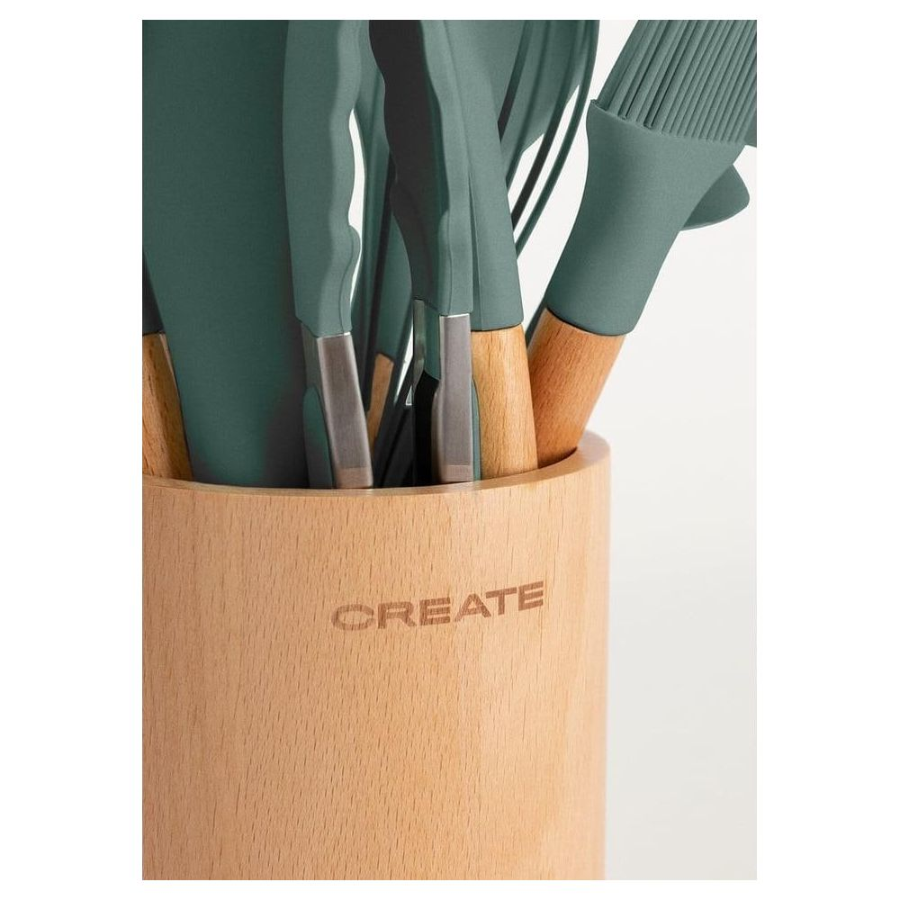Utensilios de cocina verdes con mangos de madera en un soporte de madera con la etiqueta "CREATE".