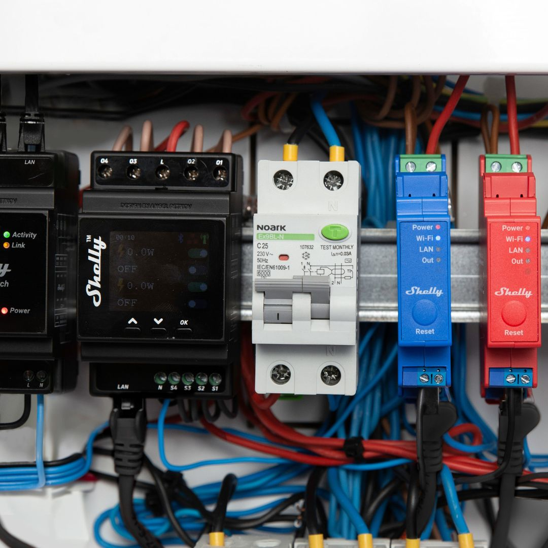 Panel elektryczny z urządzeniami Shelly, wyłącznikiem i okablowaniem.
