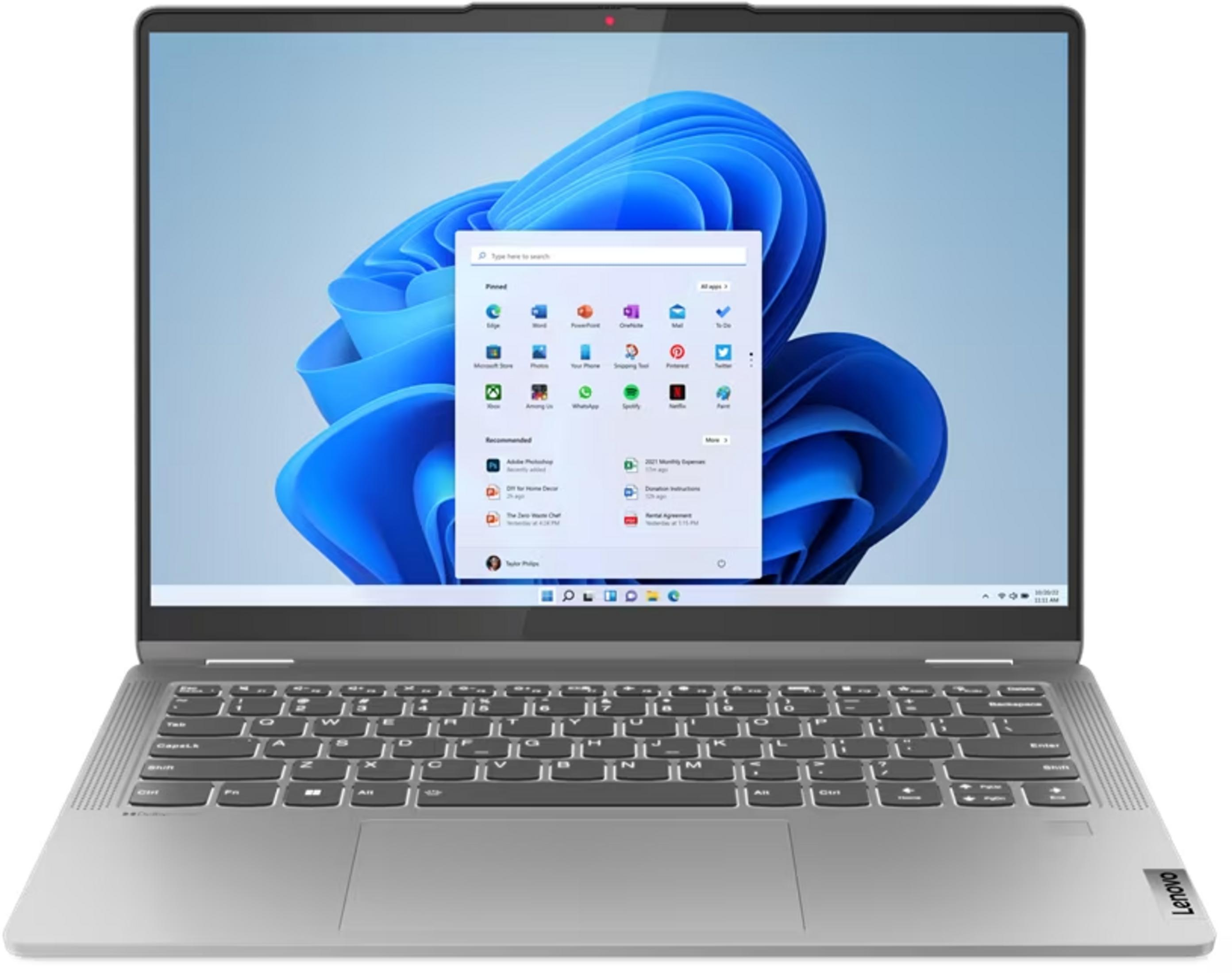 Srebrny laptop z włączonym ekranem, wyświetlający system Windows 11.