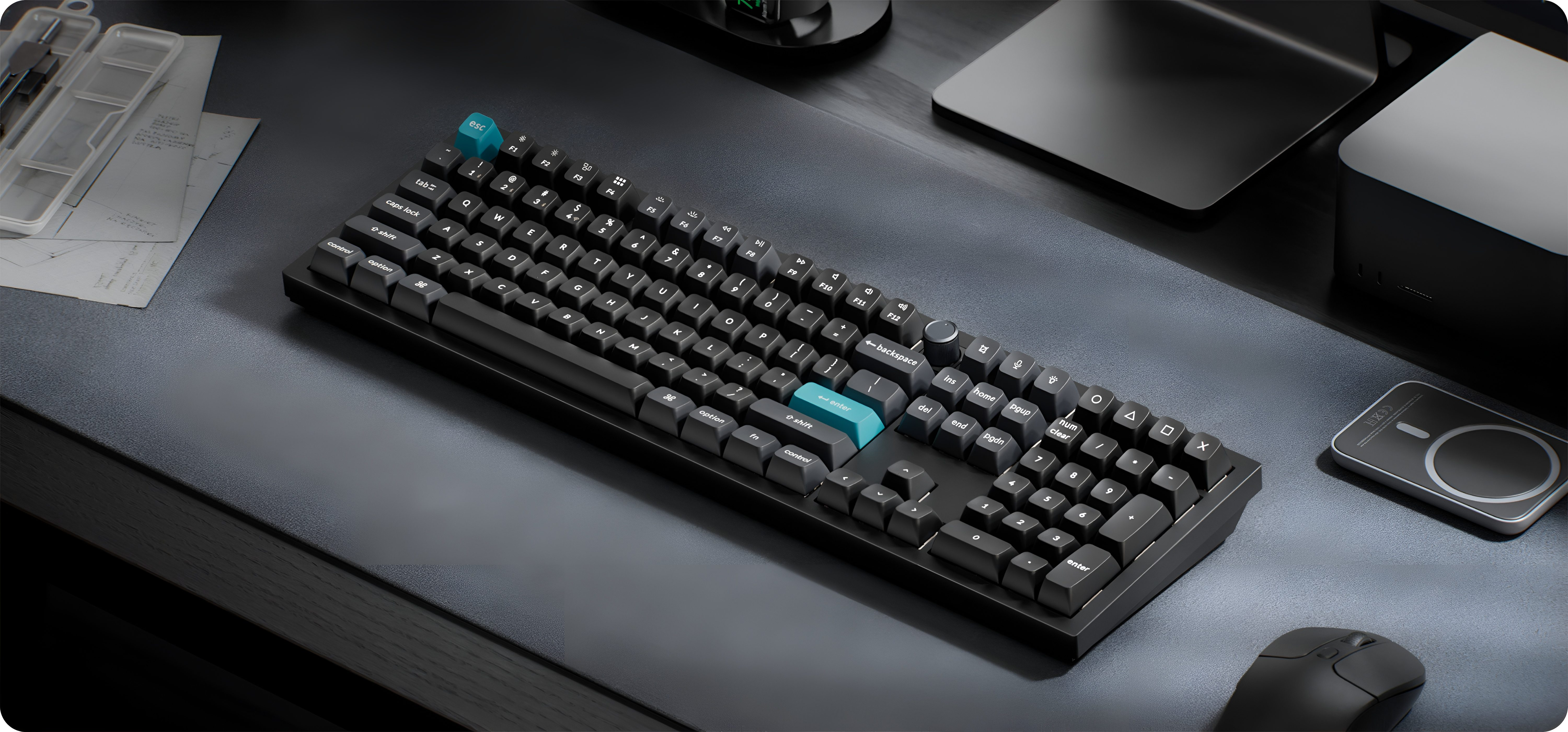 Czarna klawiatura z niebieskimi klawiszami akcentującymi na biurku z myszką i notatkami.