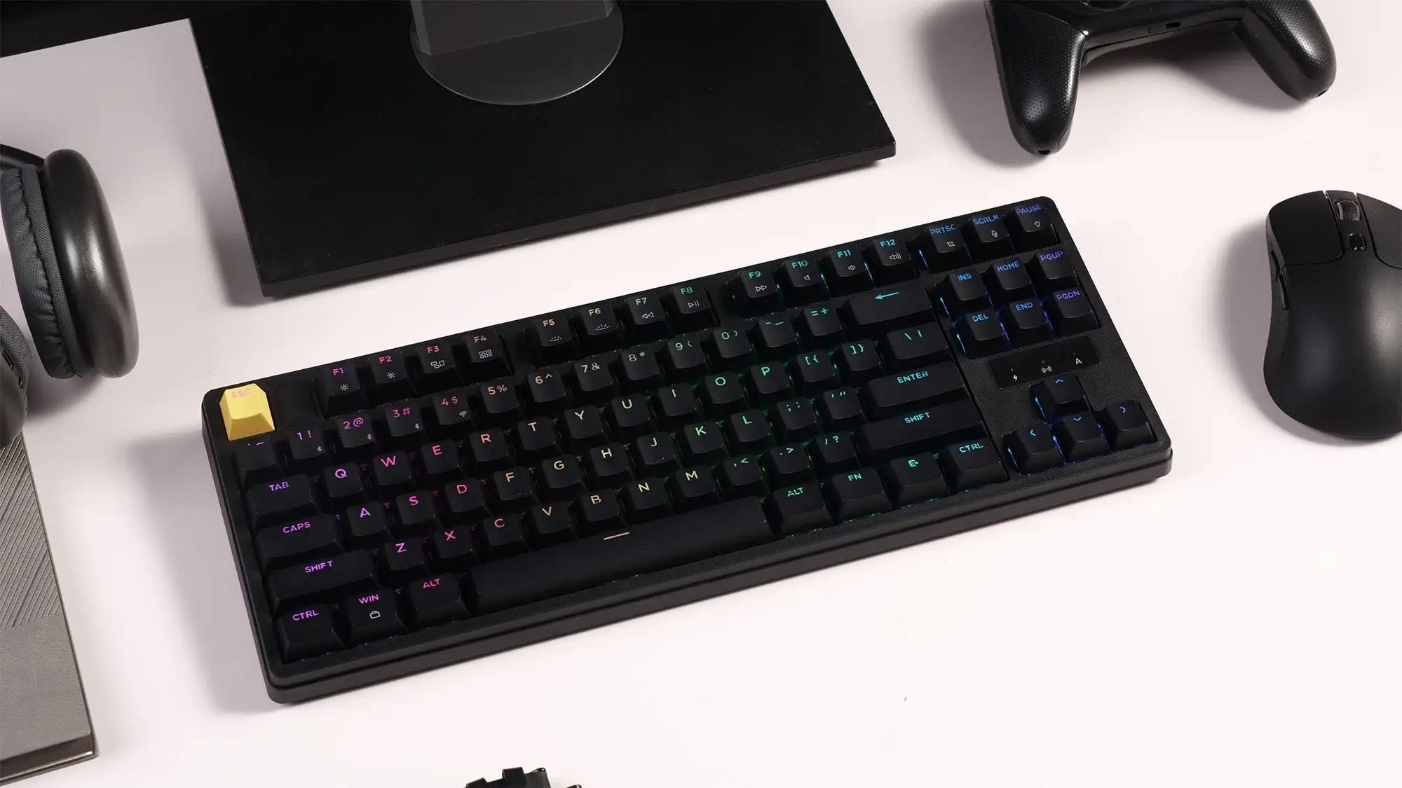 Czarna klawiatura gamingowa z podświetleniem RGB, myszą, słuchawkami i kontrolerem.