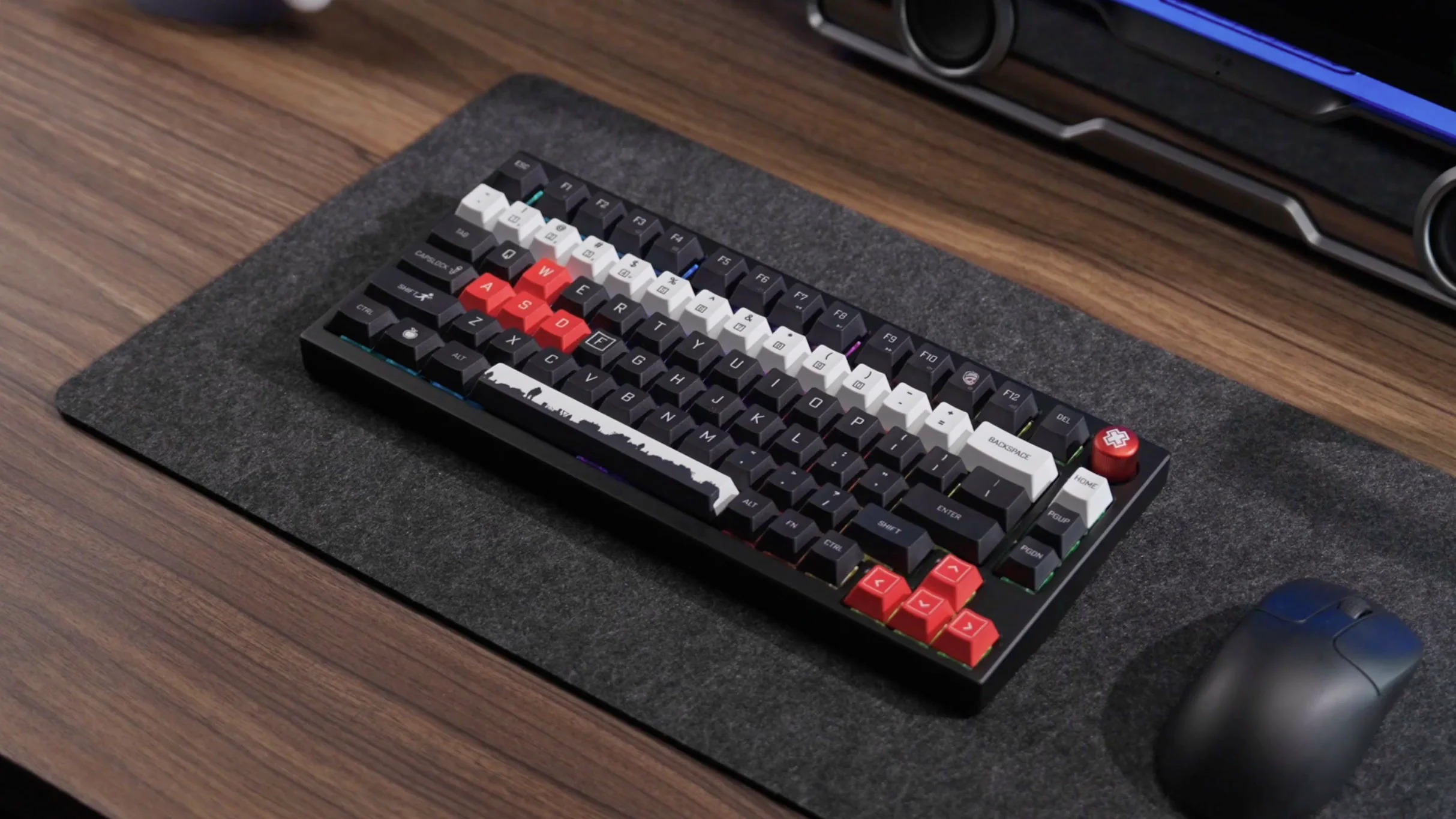 Czarna klawiatura z czerwonymi i białymi klawiszami na szarej macie.
