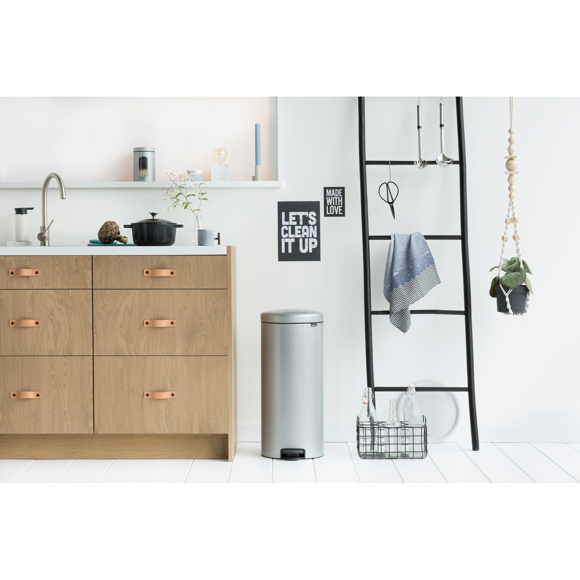 Modern kitchen with wooden cabinets, a silver bin, and a ladder.
