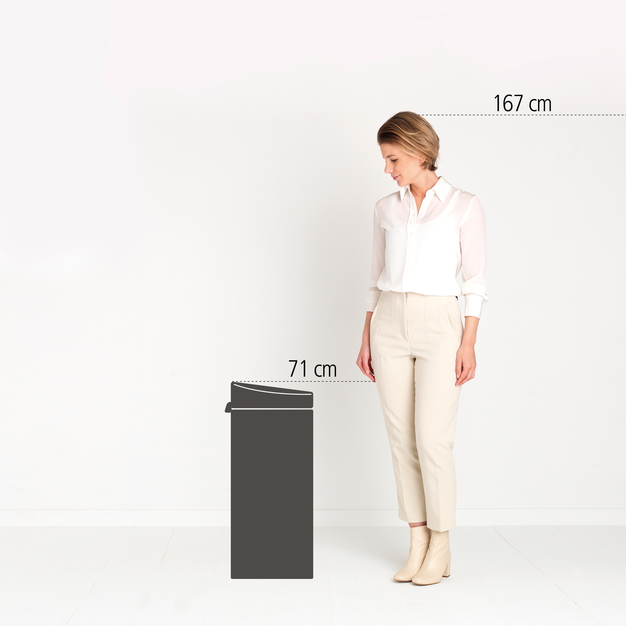 Een vrouw staat naast een prullenbak van 71 cm. Ze is 167 cm lang.