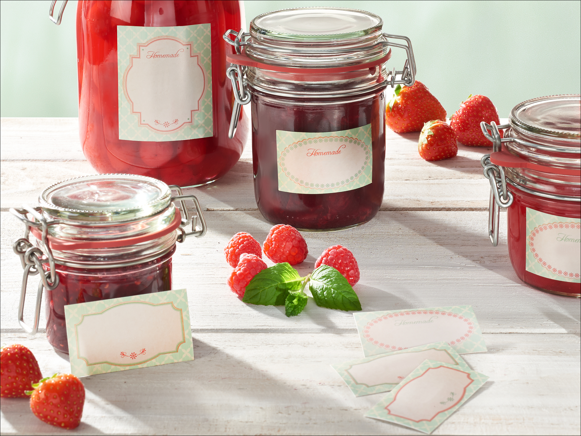 Gläser mit Marmelade, Erdbeeren und Himbeeren auf Holztisch.