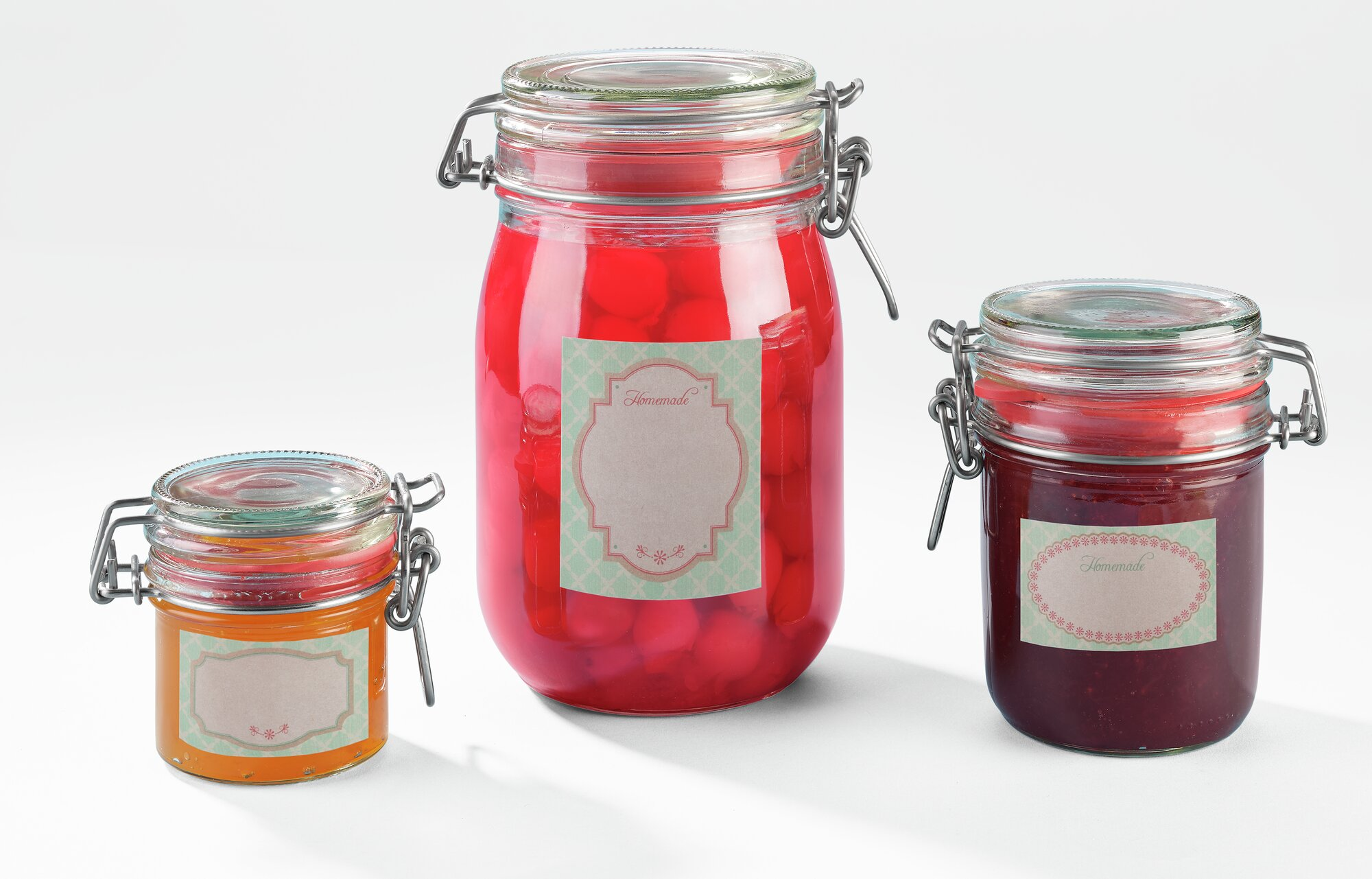 Drei Einmachgläser mit Bügelverschluss, gefüllt mit Marmelade und Früchten.