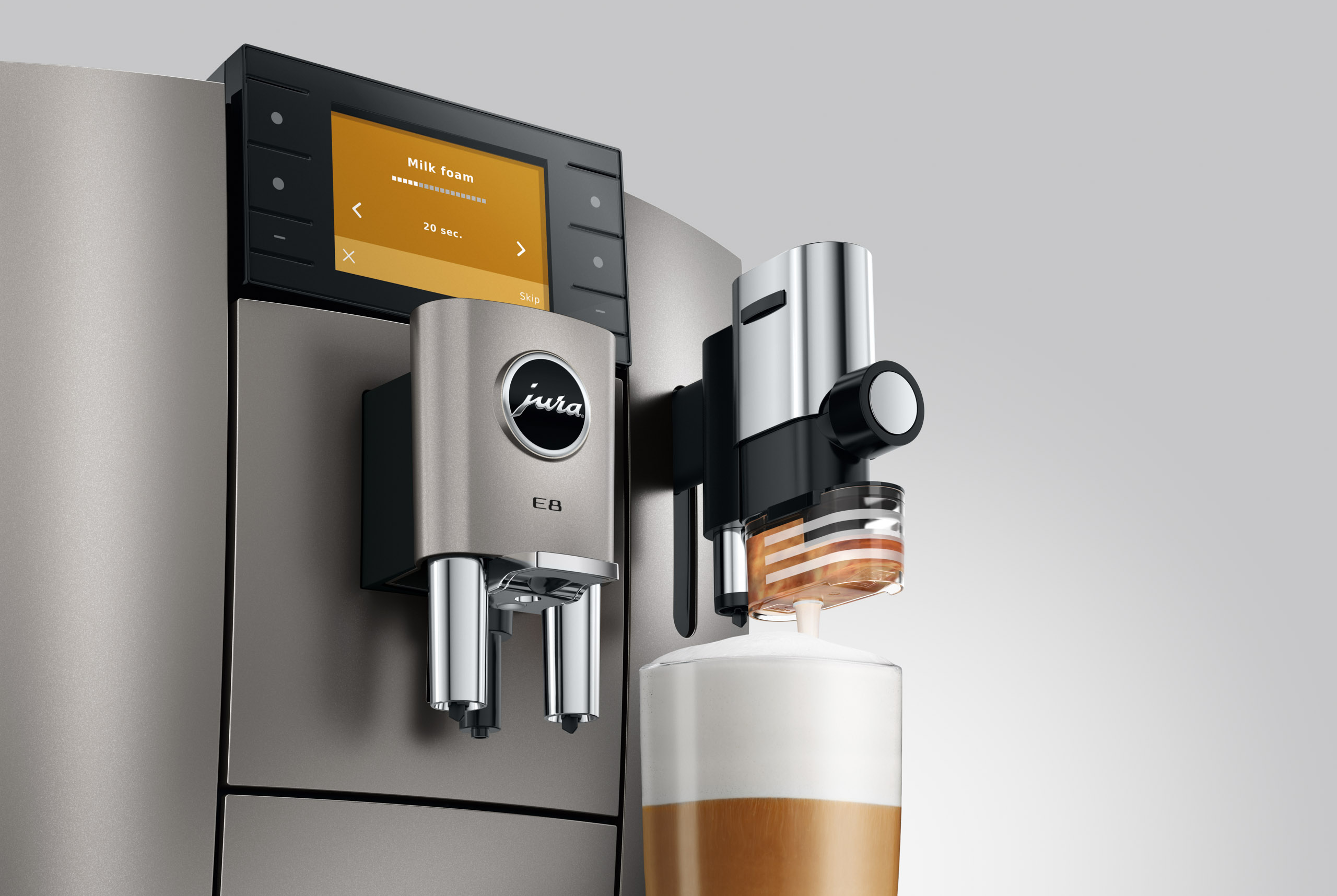 Macchina da caffè con montalatte prepara bevanda, display mostra 