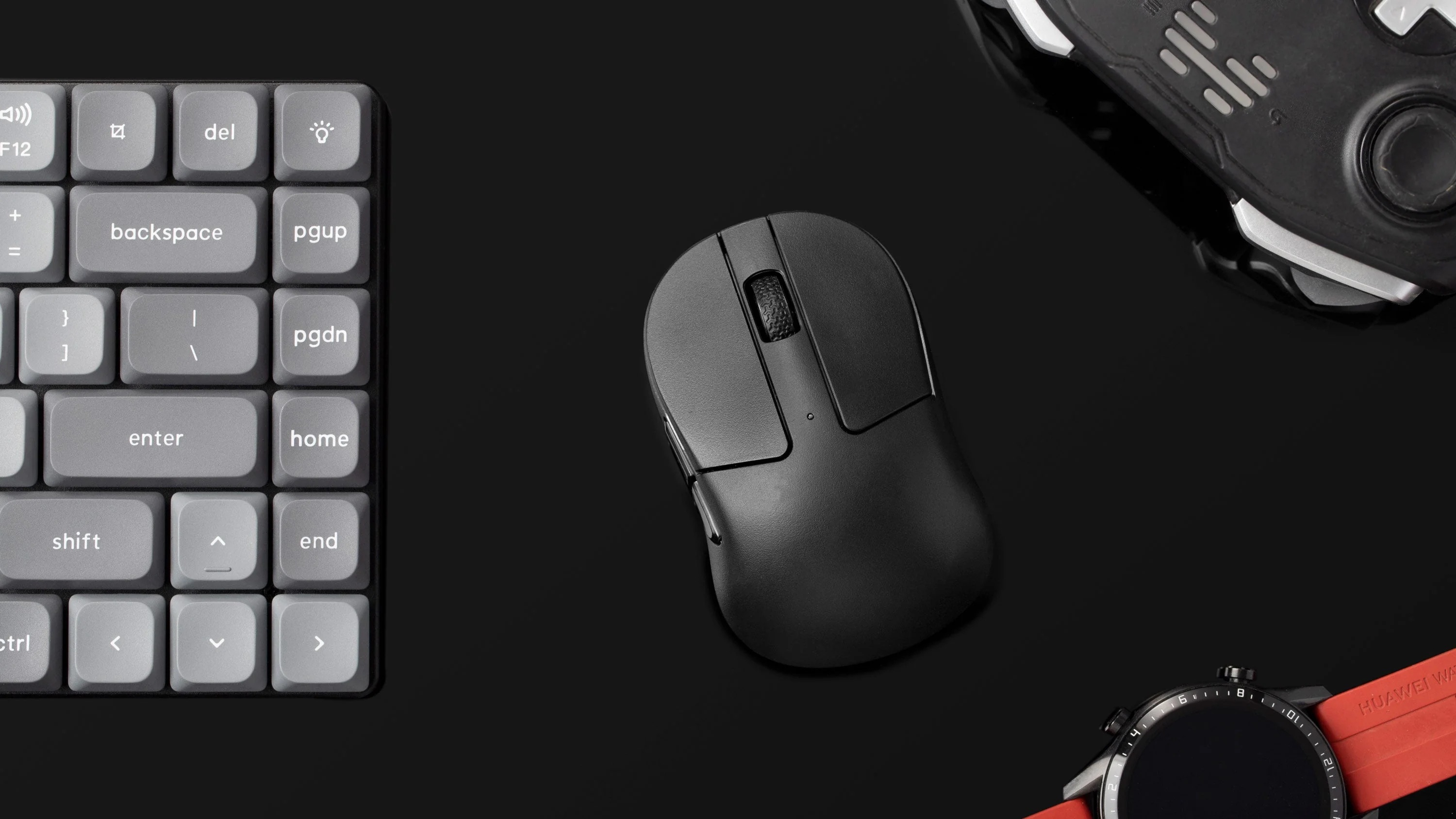 Szara klawiatura, czarna mysz i kontroler do gier na czarnej powierzchni.