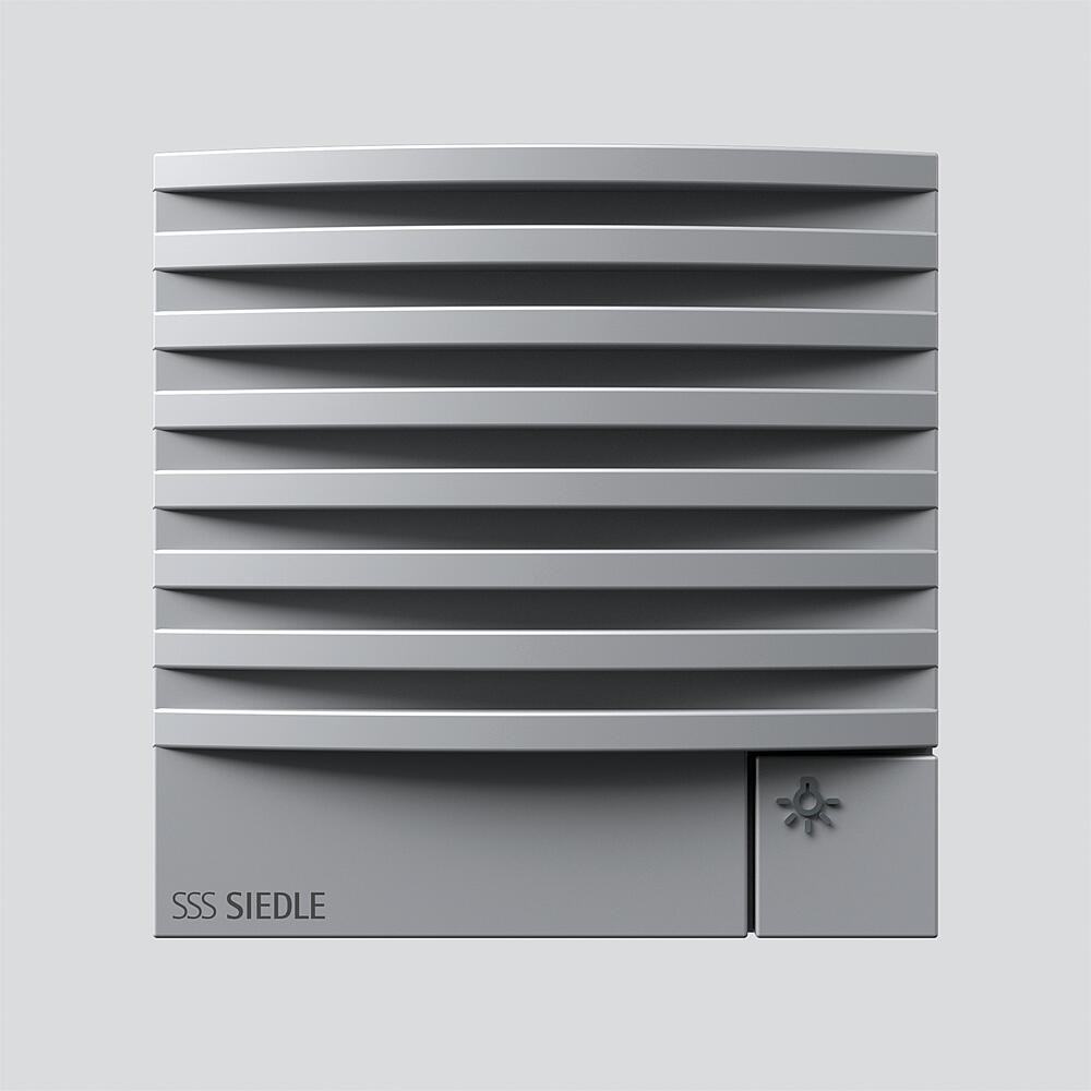 Griglia di ventilazione grigia con lamelle orizzontali e un piccolo simbolo luminoso.