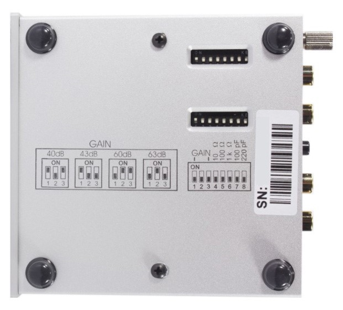 Tył srebrnego urządzenia z przełącznikami wzmocnienia, przełącznikami DIP i złączami.