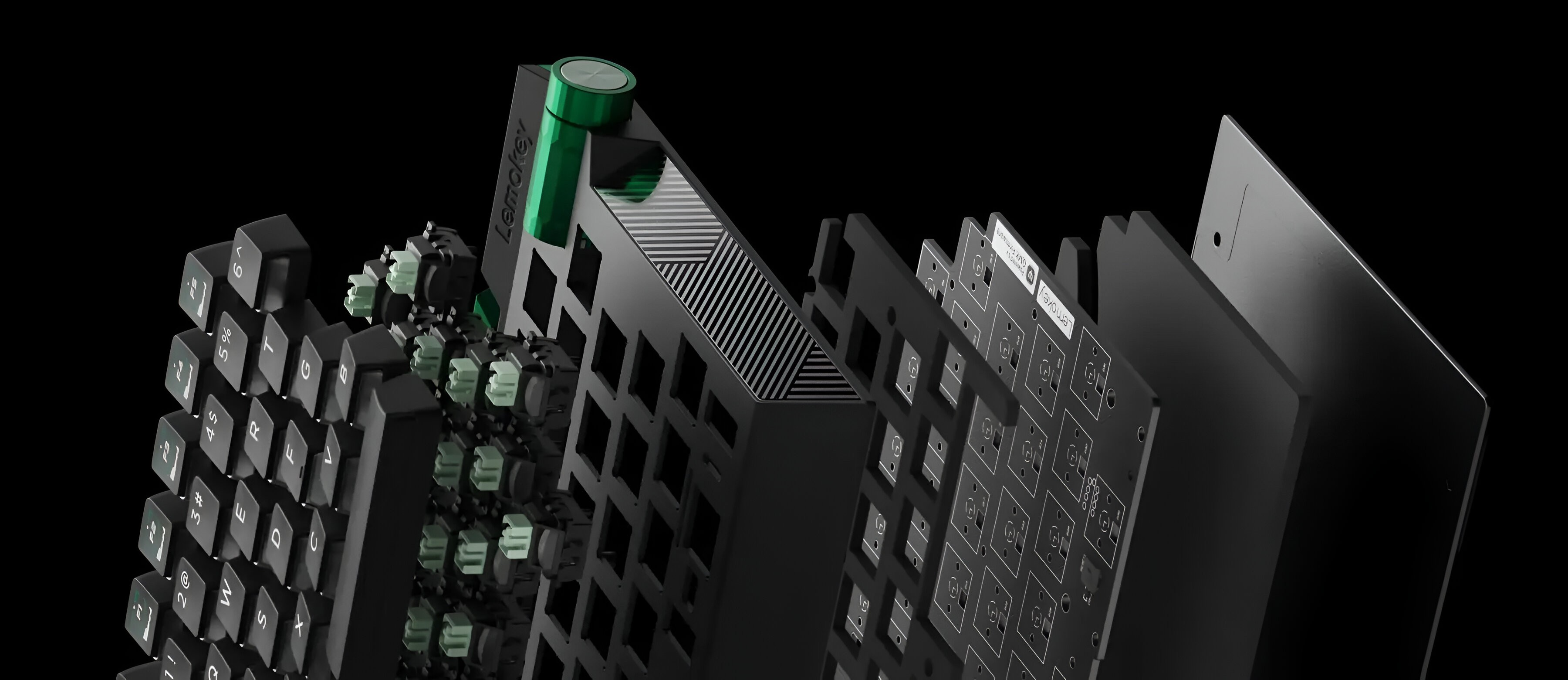 Widok rozstrzelony klawiatury: czarne klawisze, zielone przełączniki, płytka drukowana.