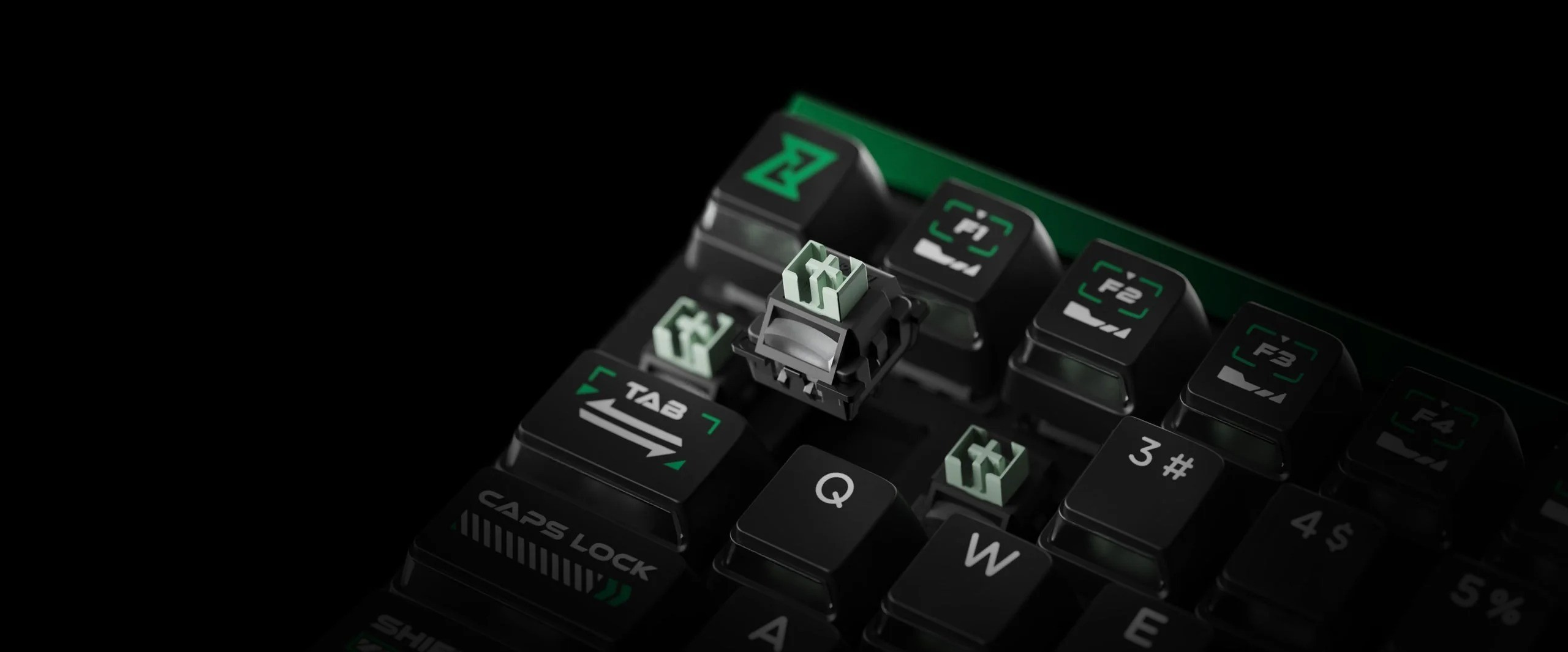 Zbliżenie klawiatury z zielonymi akcentami. Brakuje klawisza, widoczny jest przełącznik.
