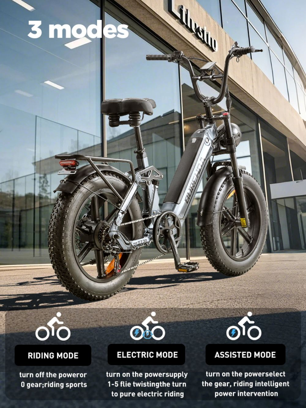 Una bici elettrica grigia con copertoni larghi davanti a un edificio moderno.
