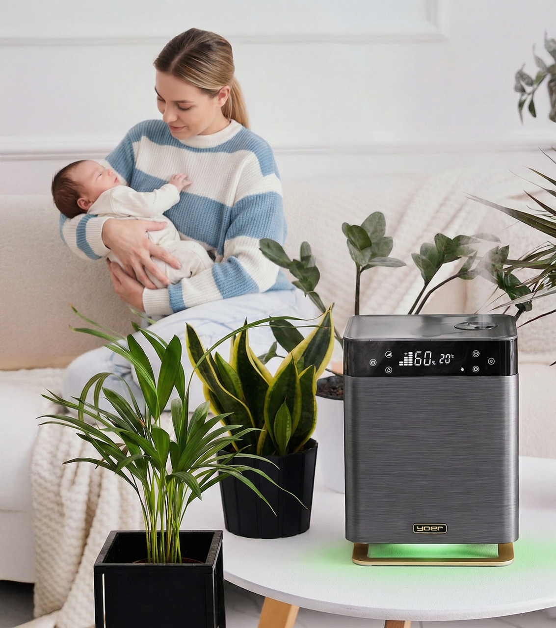 Kobieta z dzieckiem na kanapie, z roślinami i nawilżaczem na stole.