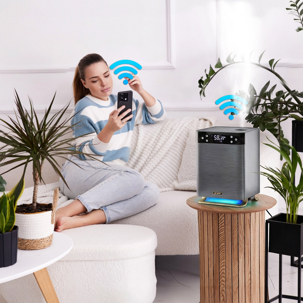 Kobieta na kanapie używa smartfona obok oczyszczacza powietrza z symbolami WiFi. Rośliny.