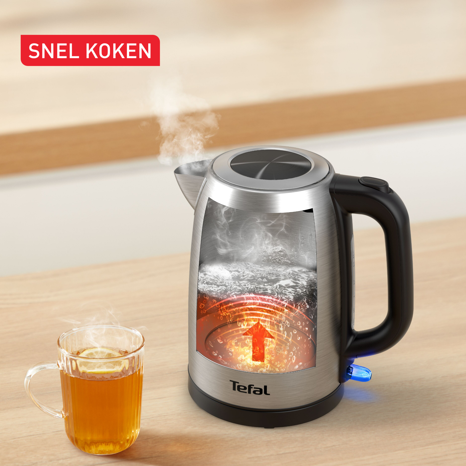 Ein durchgeschnittener Wasserkocher zeigt kochendes Wasser, Dampf steigt auf. Daneben eine Tasse Tee.