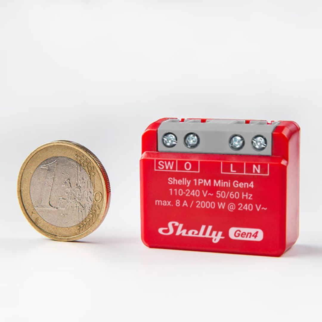 Czerwone urządzenie Shelly 1PM Mini Gen4 obok monety 1 euro.