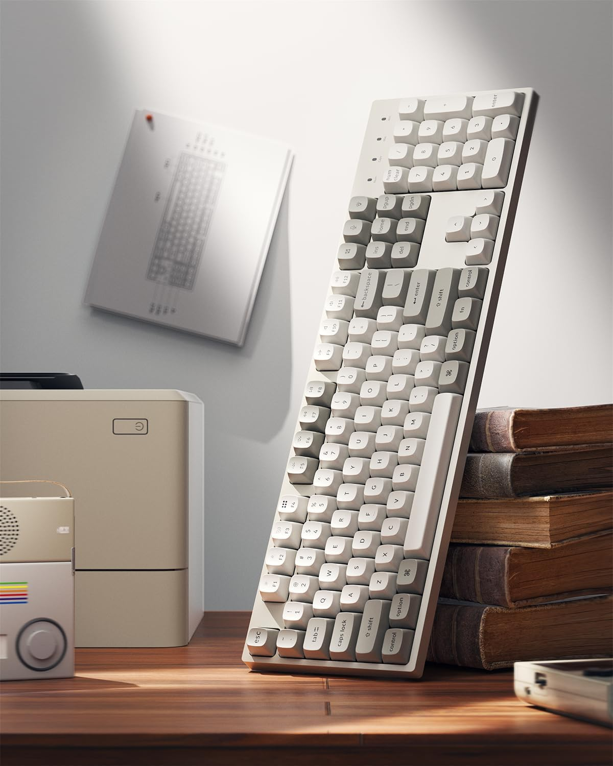 Beżowa klawiatura stoi na drewnianym biurku obok książek i drukarki.