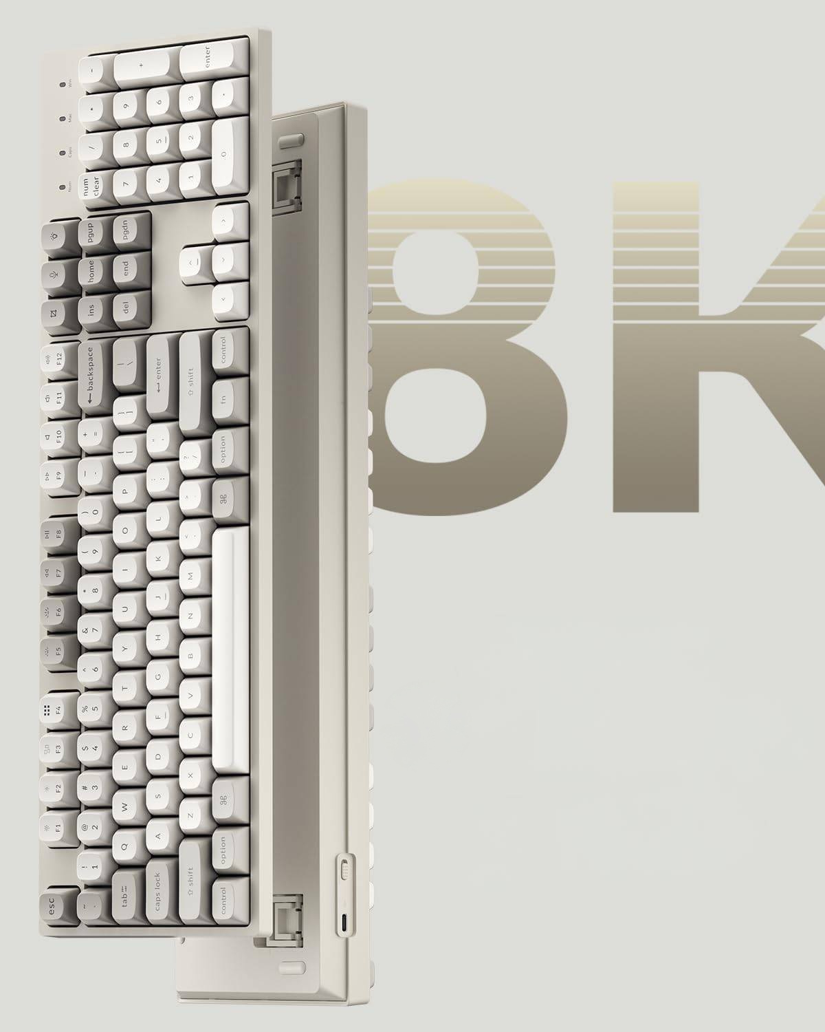 Widoczna jest beżowa klawiatura mechaniczna z białymi klawiszami. W tle widnieje napis 'BK'.